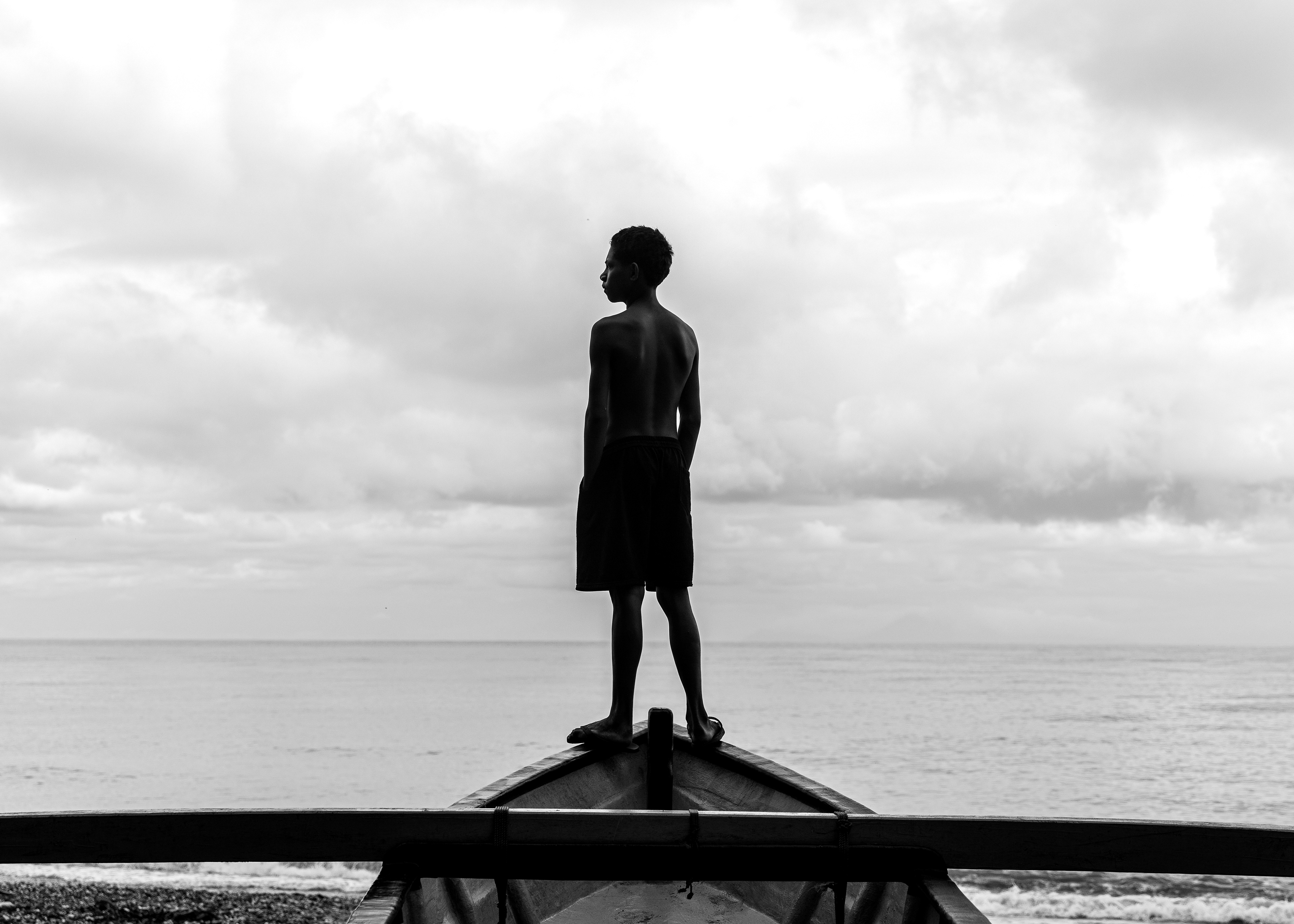 In this striking photograph, a young boy stands atop a “Bero” (traditional fishing boat) in Sumlili, his keen eyes scanning the horizon for signs of fish and changing weather. This simple act is a vital tradition passed down through generations in this coastal village, where fishing is a way of life. Here, the sea is a lifeline, providing daily sustenance for families who rely on their knowledge of the tides, winds and fish behaviour. Everyone in Sumlili knows how to fish; it is not just a skill but a shared heritage. The photograph captures a moment of quiet determination, reflecting a community where the sea’s bounty is a means of survival.