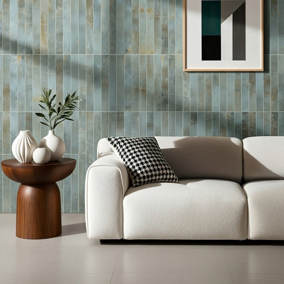 A modern lounge featuring a patinated blue and rust colored tile wall, a white boucle sofa, and a dark wood side table.