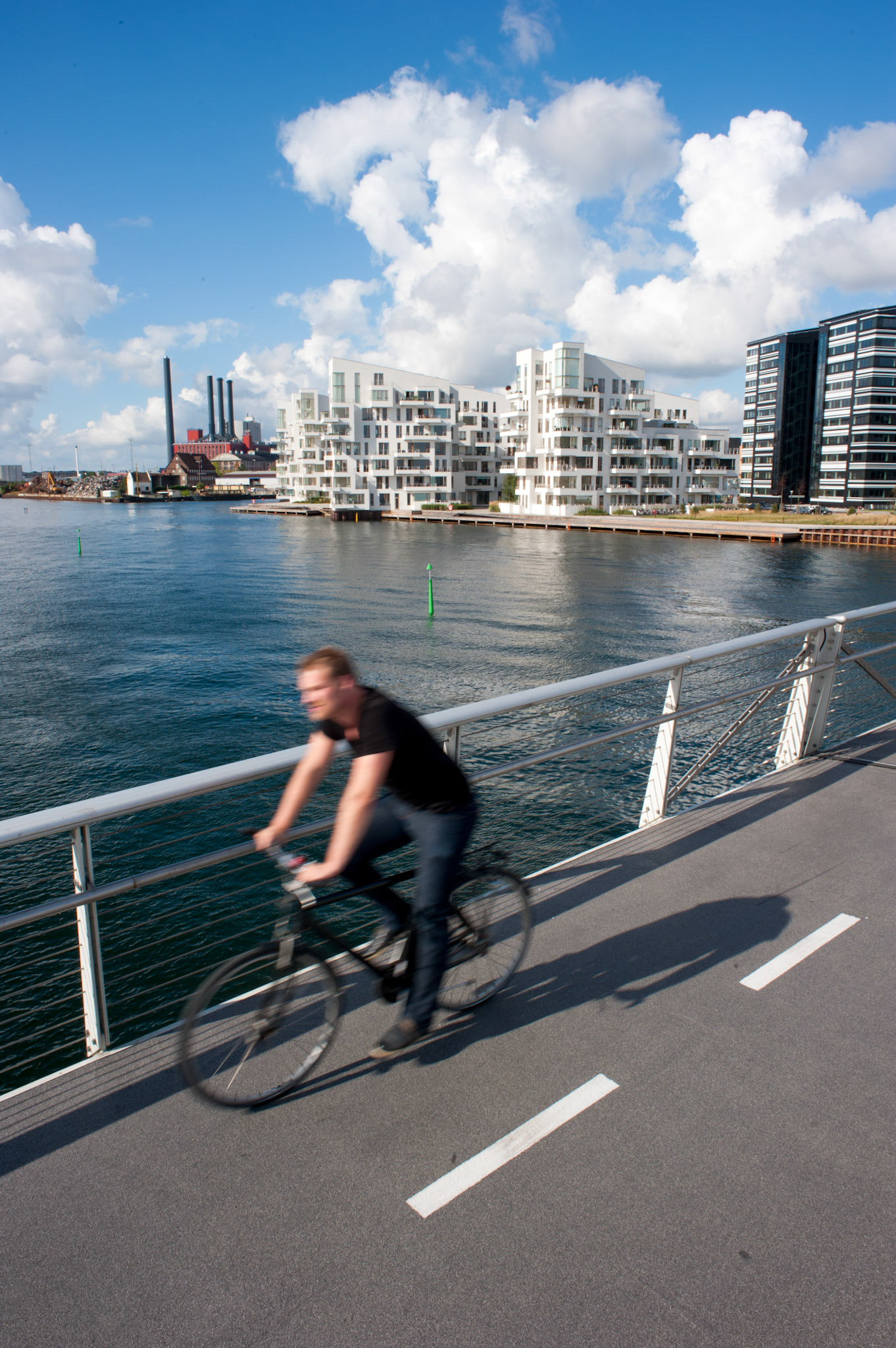 New building and bicyle crossing the harbour on a new footbridge.
