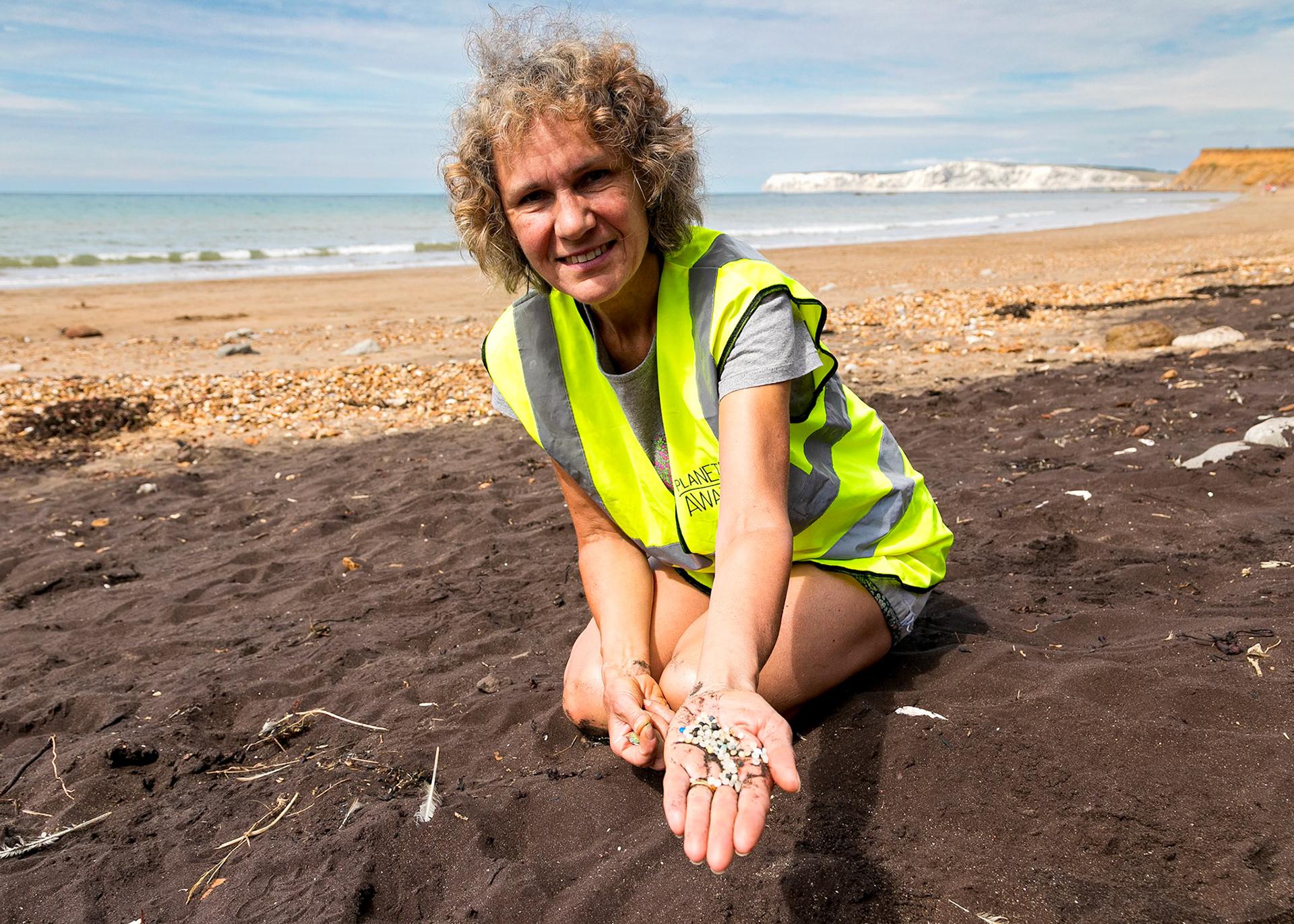Volunteer picking up plastic nurdles