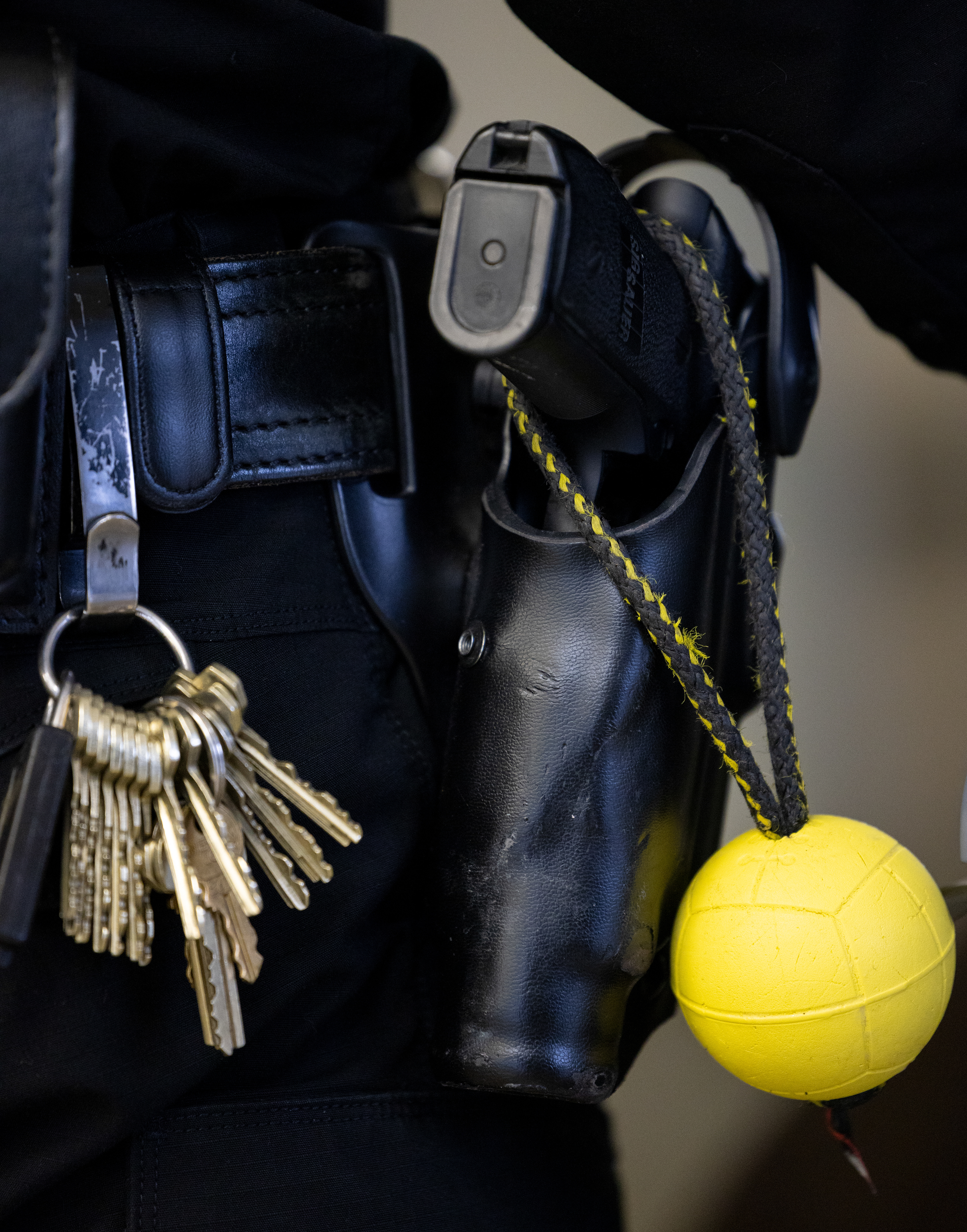 Bach’s toy ball hangs on the handle of Officer King’s gun in Athens, Ohio, Dec. 5, 2023. Bach is trained to drop the ball on command and will not touch it unless given permission. Bach can tell when Officer King is disappointed in him and learns to not let the happen.