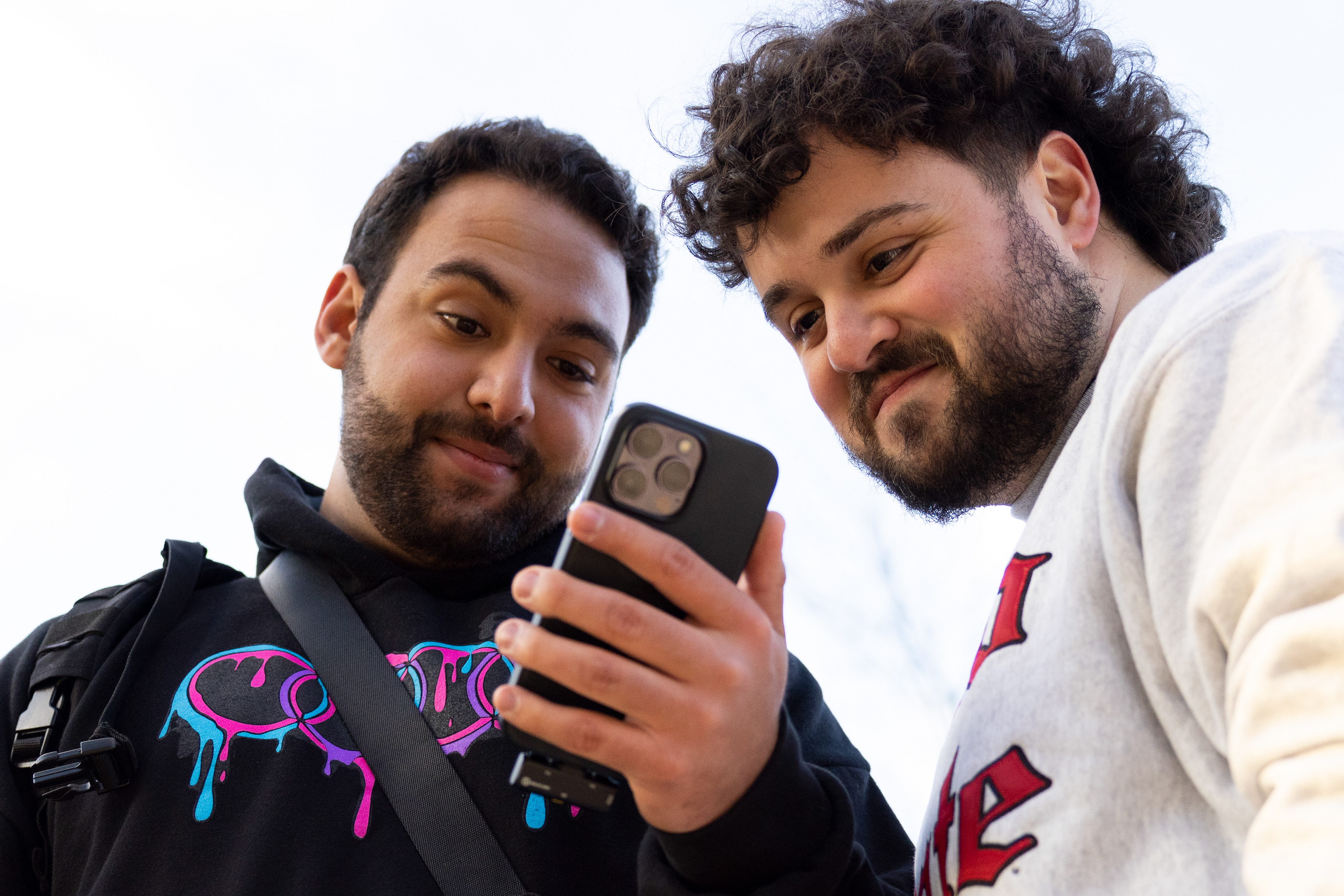 Alex Soas (left) shows Elie Haoui (right) the interview they just filmed for their social media at Ohio State University in Columbus, Ohio, Feb 2, 2024. The two cousins have hundreds of thousands of followers on their page @Eliemagic. The page consists of comedic interviews and dance videos.