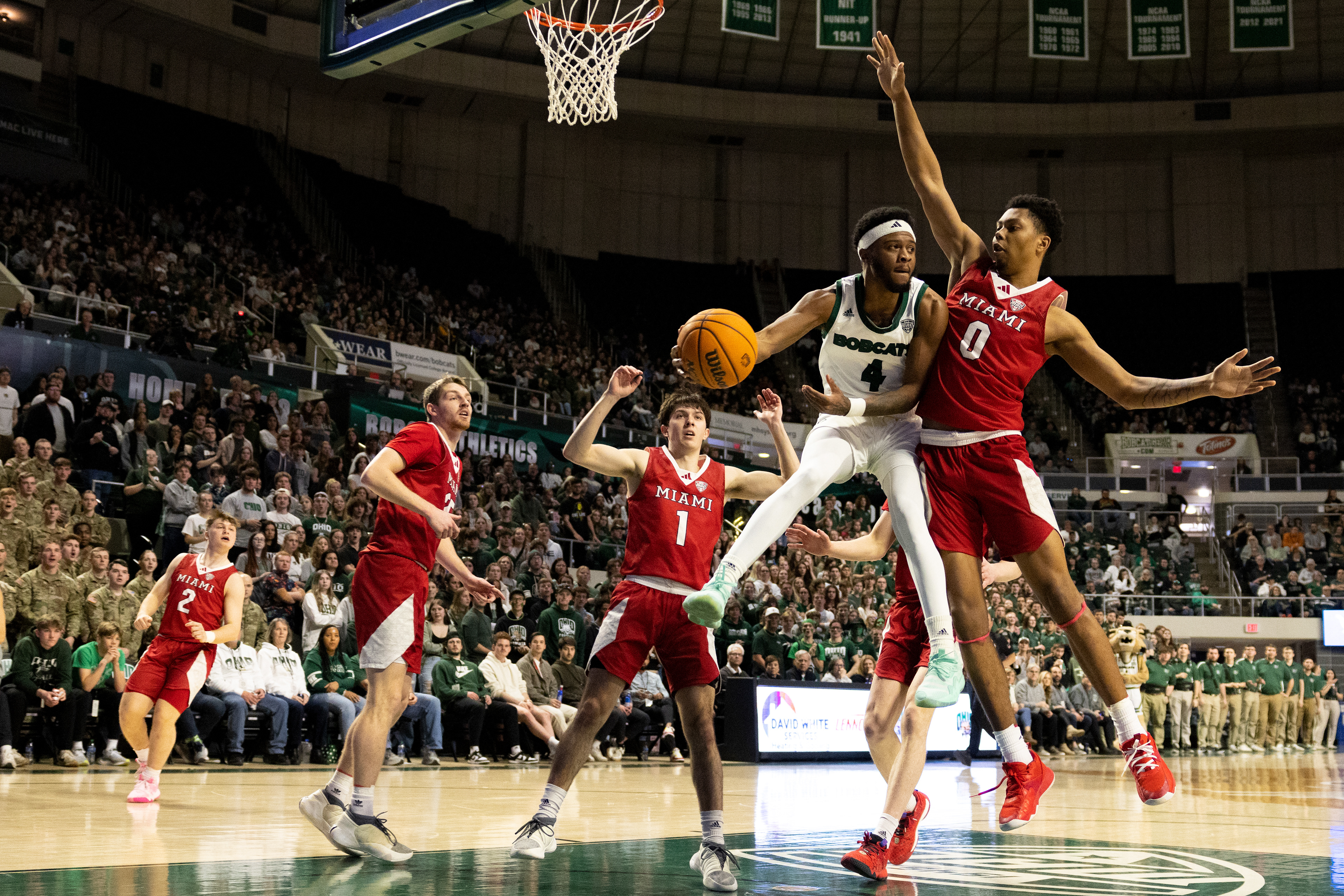 Ohio University guard, Shereef Mitchell (4), fakes a layup and passes the ball around a Miami University player at the Convocation Center in Athens, Ohio, Feb. 3, 2024.