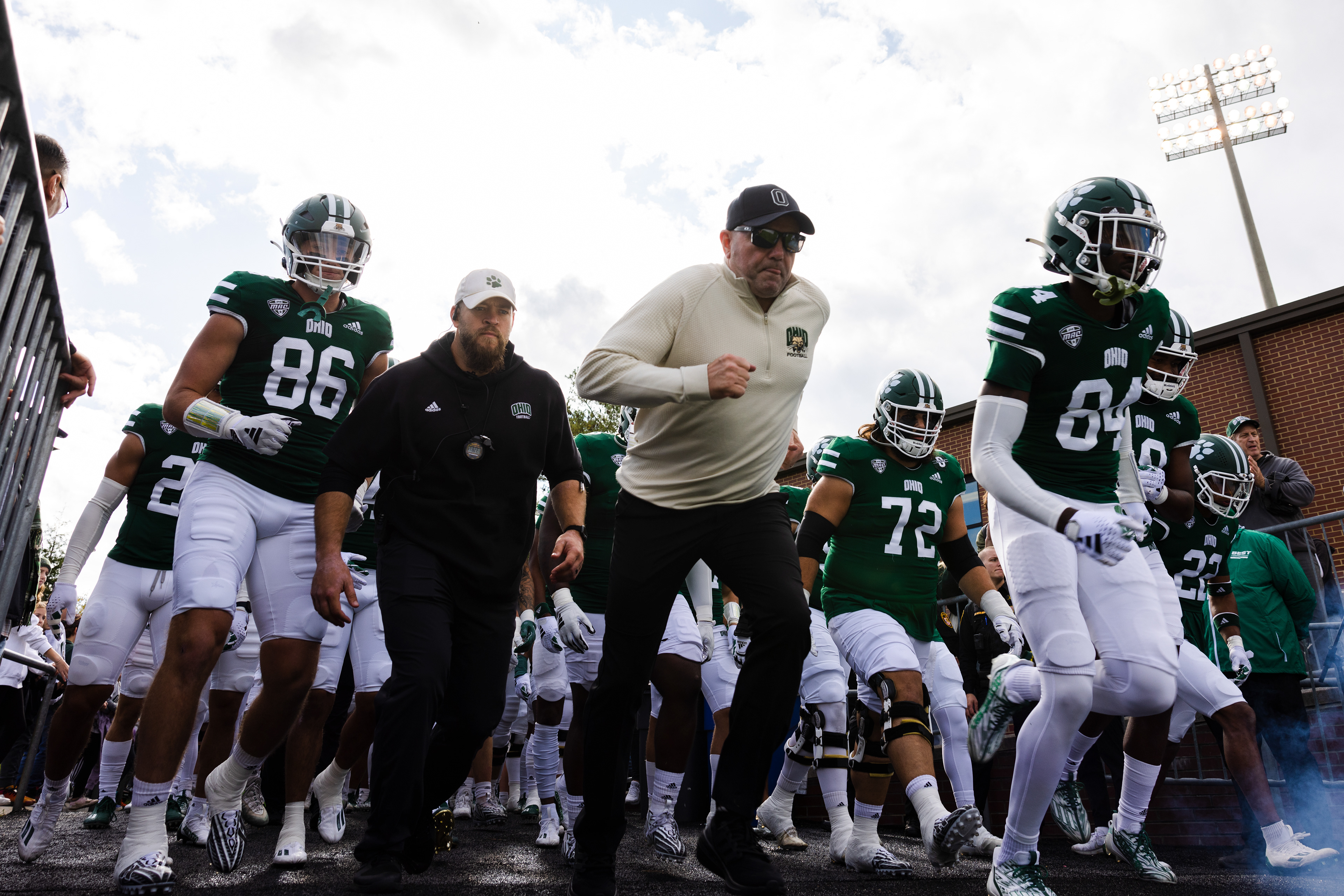 The Ohio Bobcats run out of the tunnel led by head coach Tim Albin, center, before the game against Kent State at Peden Stadium in Athens, Ohio, Oct. 7, 2023.