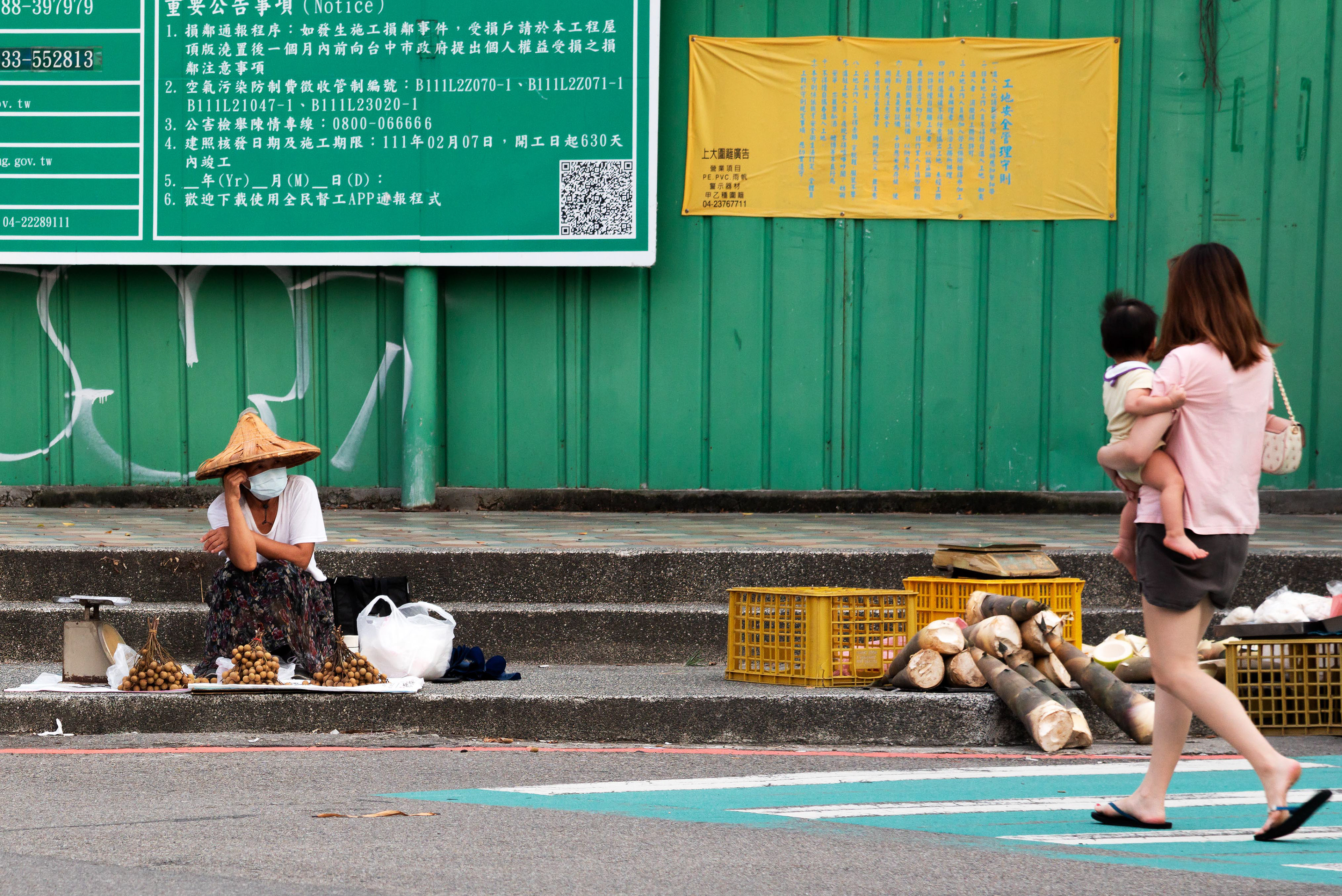 an elderly woman selling fruit by the roadside