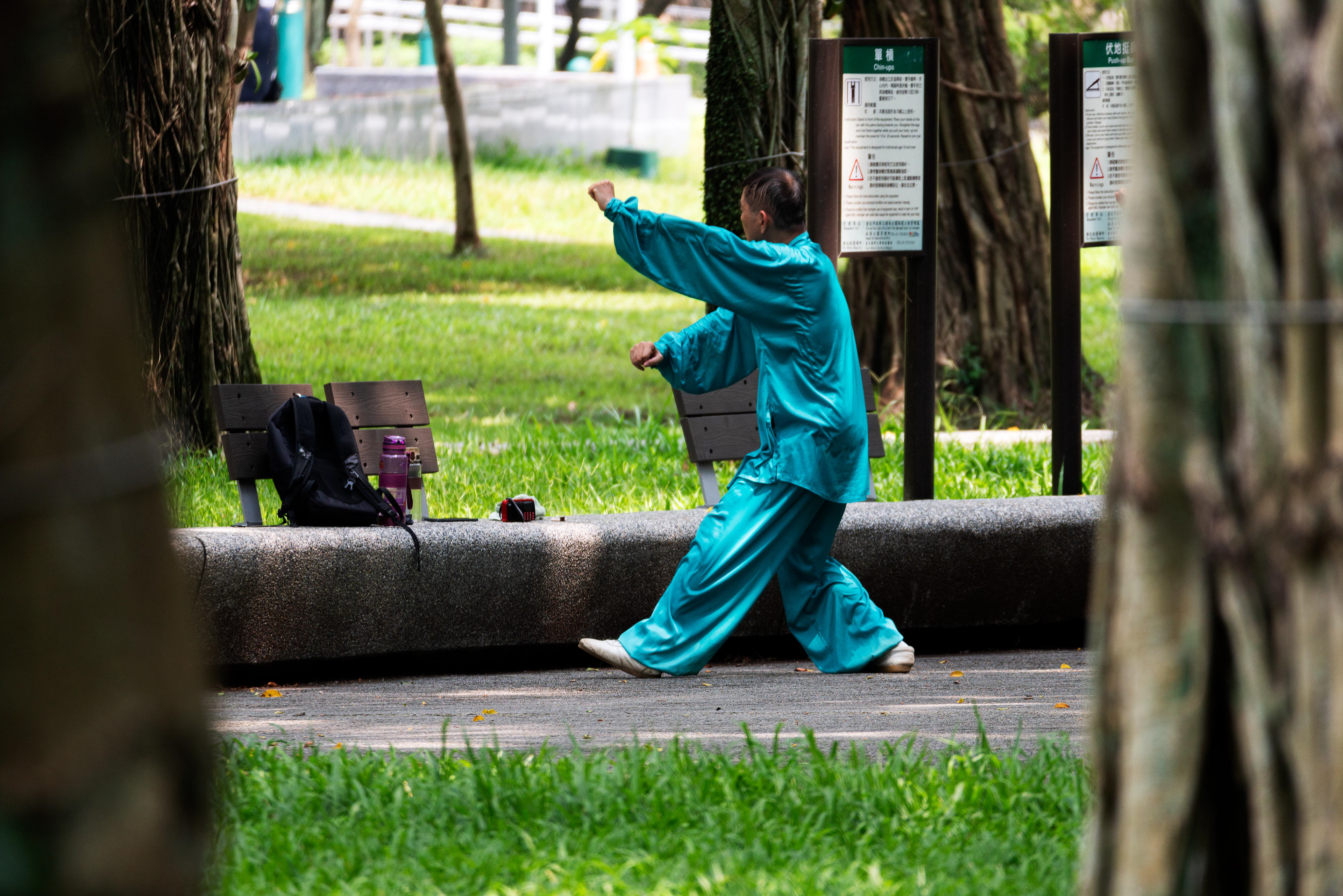 a man practices tai chi in a park in Taipei