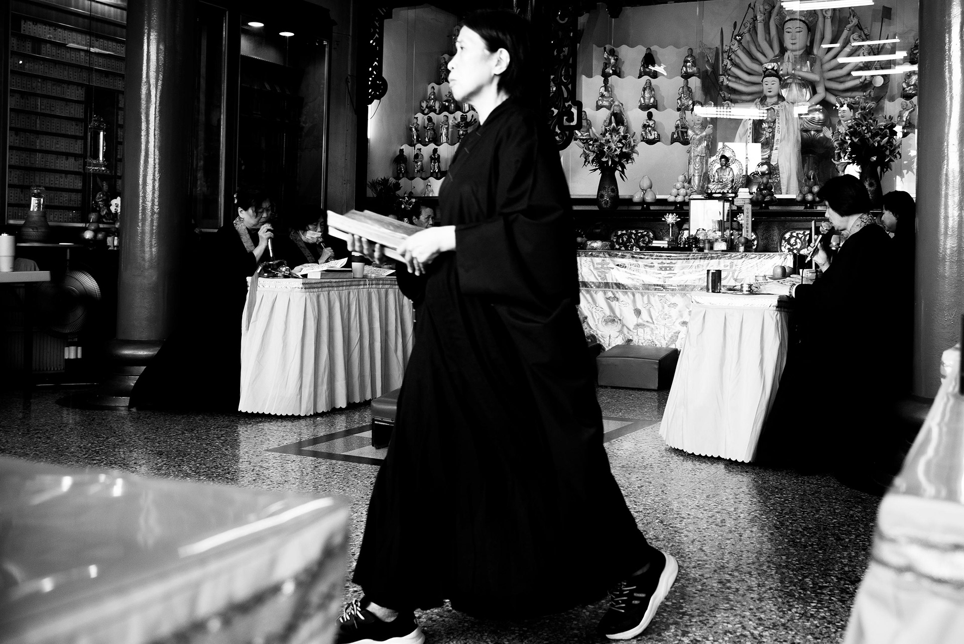 a woman devotee carefully arranges the sacred texts during the ceremony