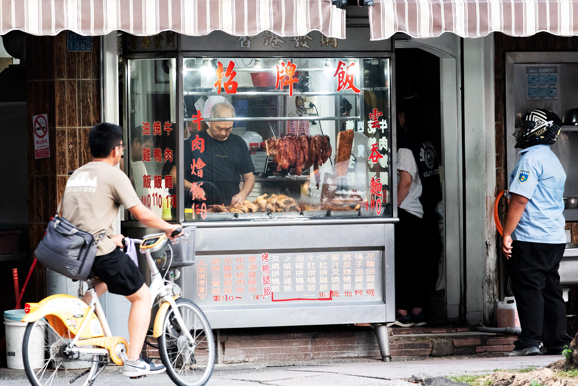 a traditional food stall on the street offering roasted duck, chicken, and pork