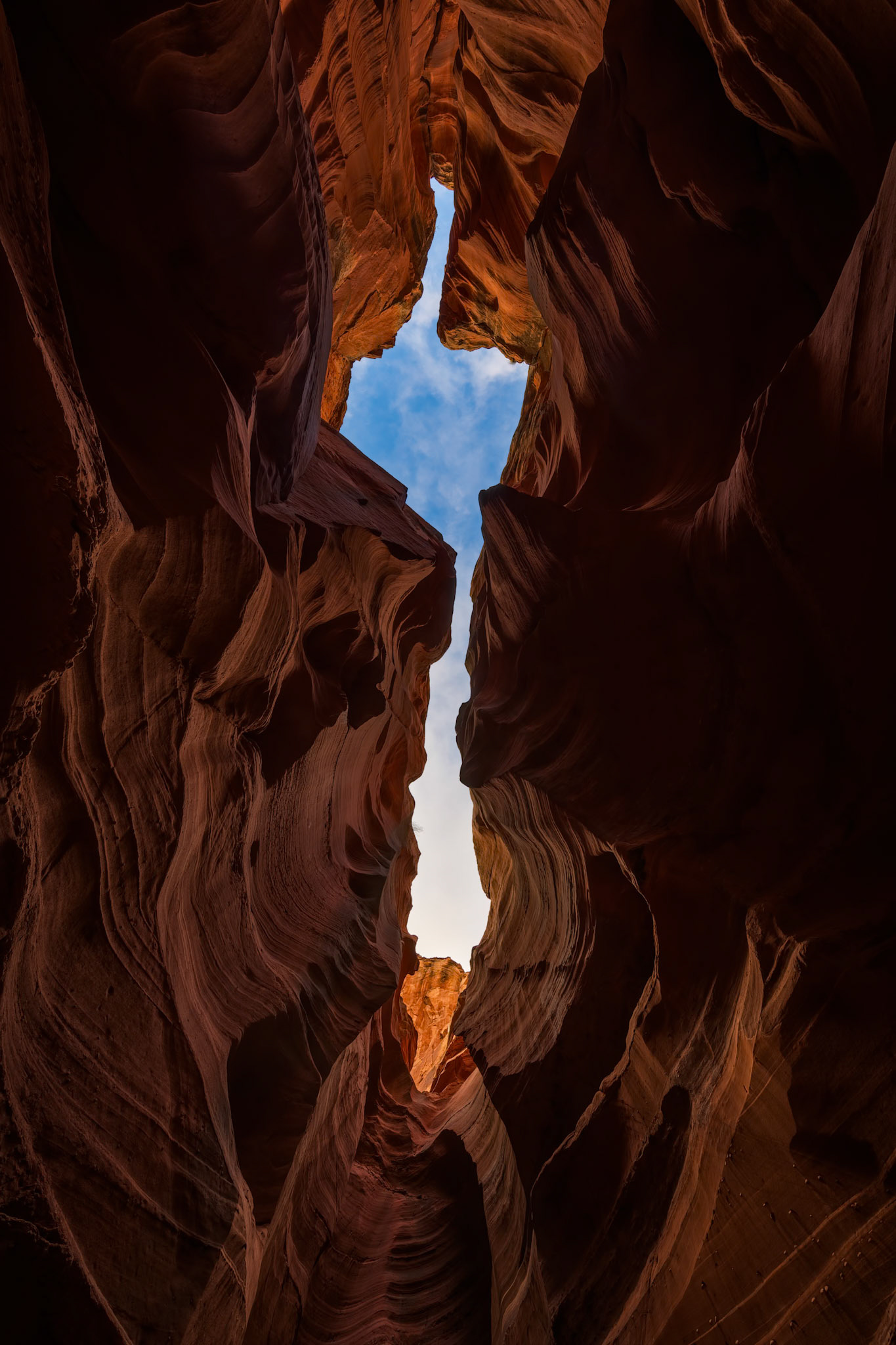 WINDOW TO THE SKY  |  Standing deep within the twisting sandstone corridors of Arizona's slot canyons, it's impossible not to see shapes, faces, and symbols hidden within the stone. The human mind is wired to find meaning in abstract forms, and this scene immediately sparked a laugh when I first noticed it.The narrow opening above, framed by centuries of erosion, appeared to convey a message that was unmistakable, at least to my imagination. I jokingly referred to it as "the Navajo's message to the U.S. Government."Of course, the canyon has no political agenda. It is simply the result of water, wind, and time patiently sculpting sandstone over millions of years. Yet that is part of the magic of places like this. Nature creates forms that invite interpretation, allowing each visitor to discover something entirely different.Some see faces. Some see animals. Some see symbols. I saw a bit of humor carved into stone.Beyond the joke, the image speaks to something deeper. These canyon walls existed long before borders, governments, or political debates. They remind us that human conflicts are fleeting, while the forces that shape our planet operate on a scale almost beyond comprehension.Sometimes nature offers perspective. Sometimes it offers a laugh.Occasionally, it manages to do both.