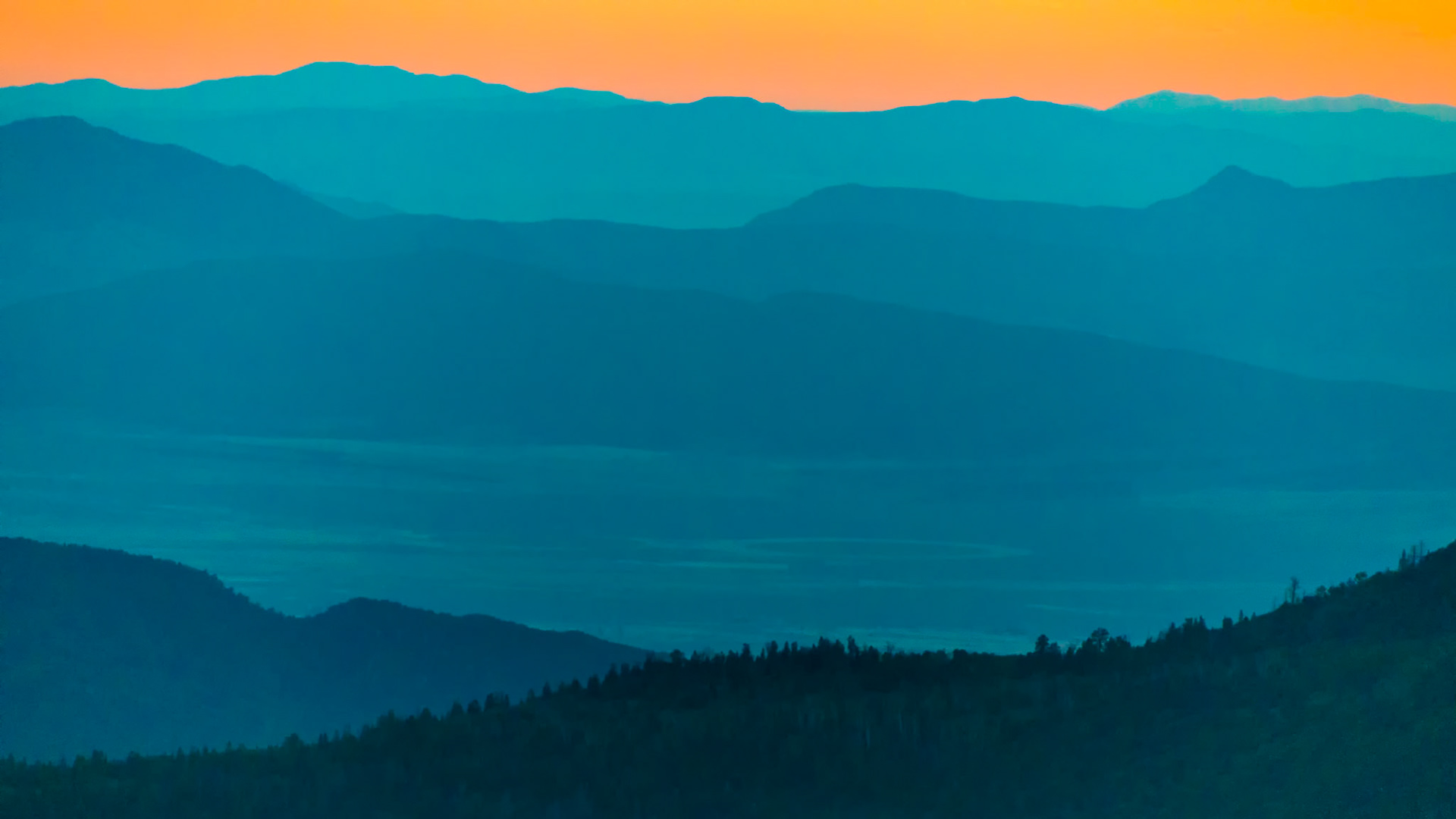 BLUE HOUR REVERIE | Some landscapes reveal themselves all at once. Others unfold one layer at a time.As the sun slipped below the horizon near Bryce Canyon, the mountains began to lose their individual identities. Ridges became silhouettes. Valleys dissolved into shadow. What remained was a remarkable procession of overlapping forms stretching toward the horizon, each more distant and mysterious than the last.The scene felt less like a photograph and more like a watercolor painting. Cool blue layers receded endlessly into the distance while the sky retained the last warm glow of the departing day. The contrast between the fiery horizon and the tranquil mountains created a sense of calm that can only be experienced in those brief moments between day and night.What drew me to this image was its simplicity. No dramatic foreground. No iconic landmark. Just the quiet beauty of distance, atmosphere, and light revealing the landscape one layer at a time.