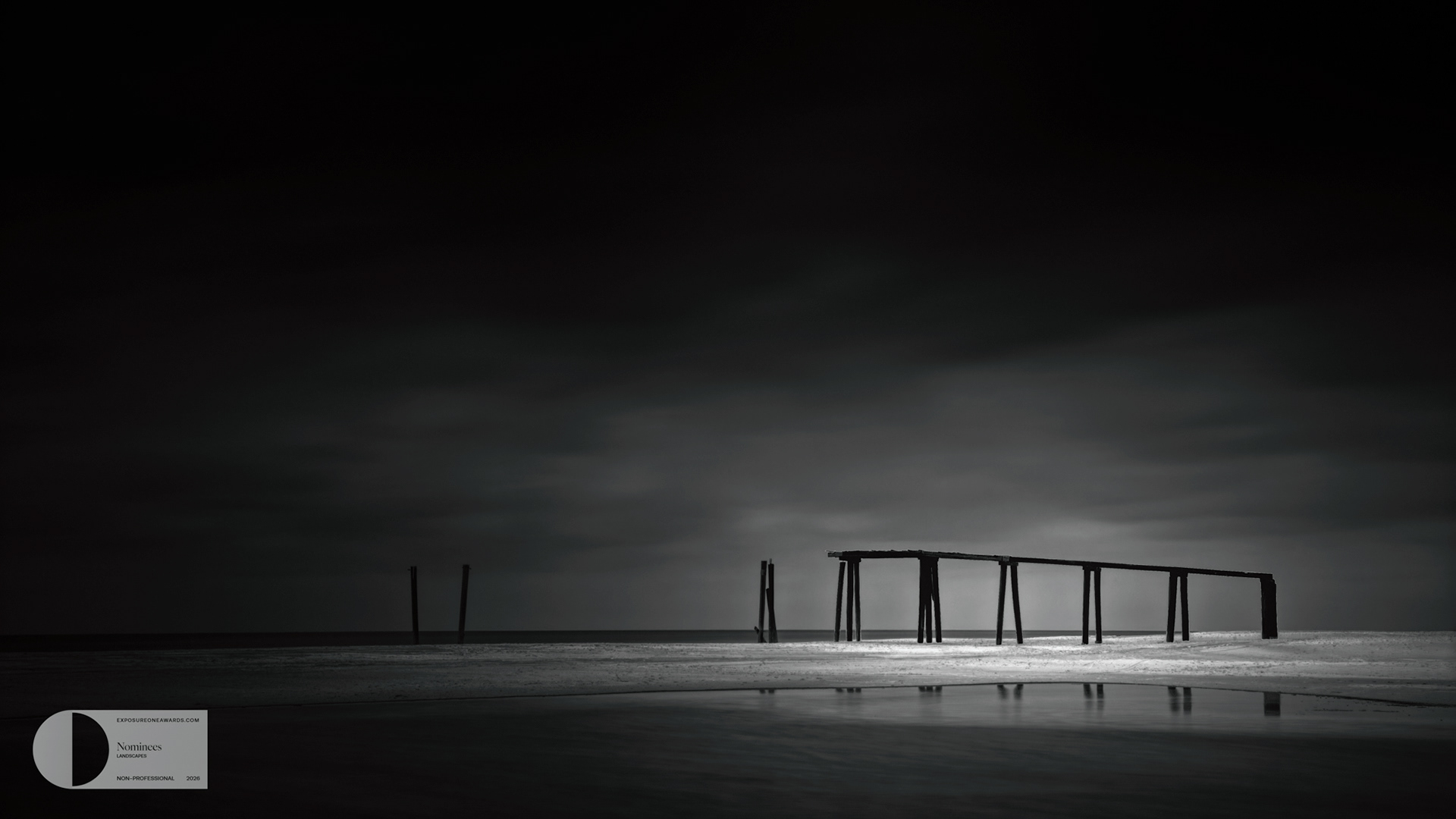 AFTER THE LAST TIDE | A broken pier stands in quiet defiance as light slips through the storm, turning absence into presence along the edge of the sea.