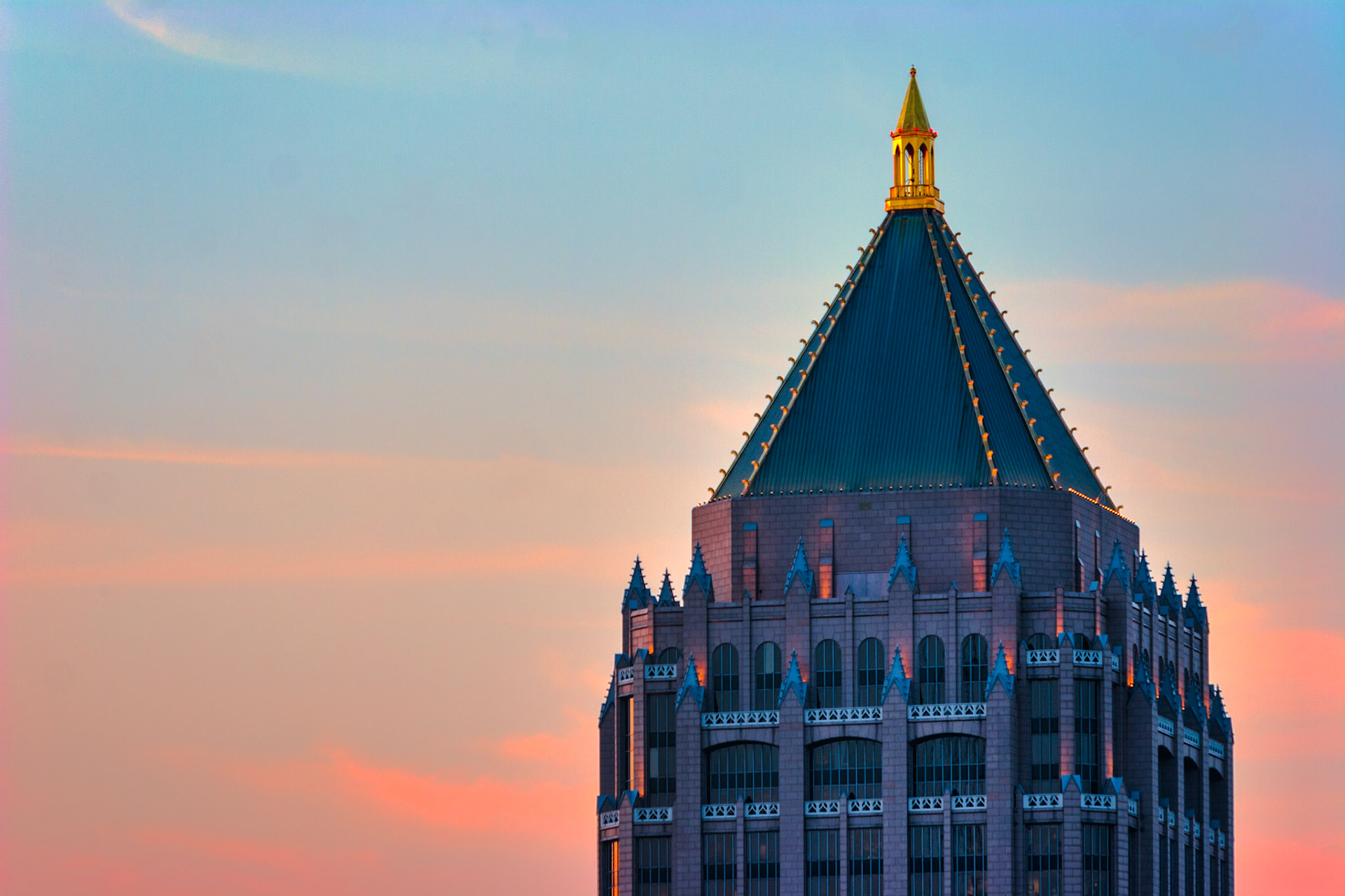 EVENING'S CROWN  |  For many years, this distinctive rooftop was one of Atlanta's most recognizable architectural signatures. Long before the city's skyline became crowded with glass towers, the former IBM Building stood as a symbol of Atlanta's emergence as a major business center in the Southeast.What attracted me to this image was its simplicity. By isolating the building's crown against the soft colors of twilight, the focus shifts from the structure itself to its elegant geometry. The warm evening sky provides a gentle backdrop for the illuminated pinnacle, transforming a familiar office tower into something almost regal.Architecture often reveals its character in the details. The building's pointed crown has always reminded me of a modern cathedral spire, designed not for worship but for commerce, ambition, and progress. Even among newer skyscrapers, its silhouette remains instantly recognizable to those who know Atlanta.
