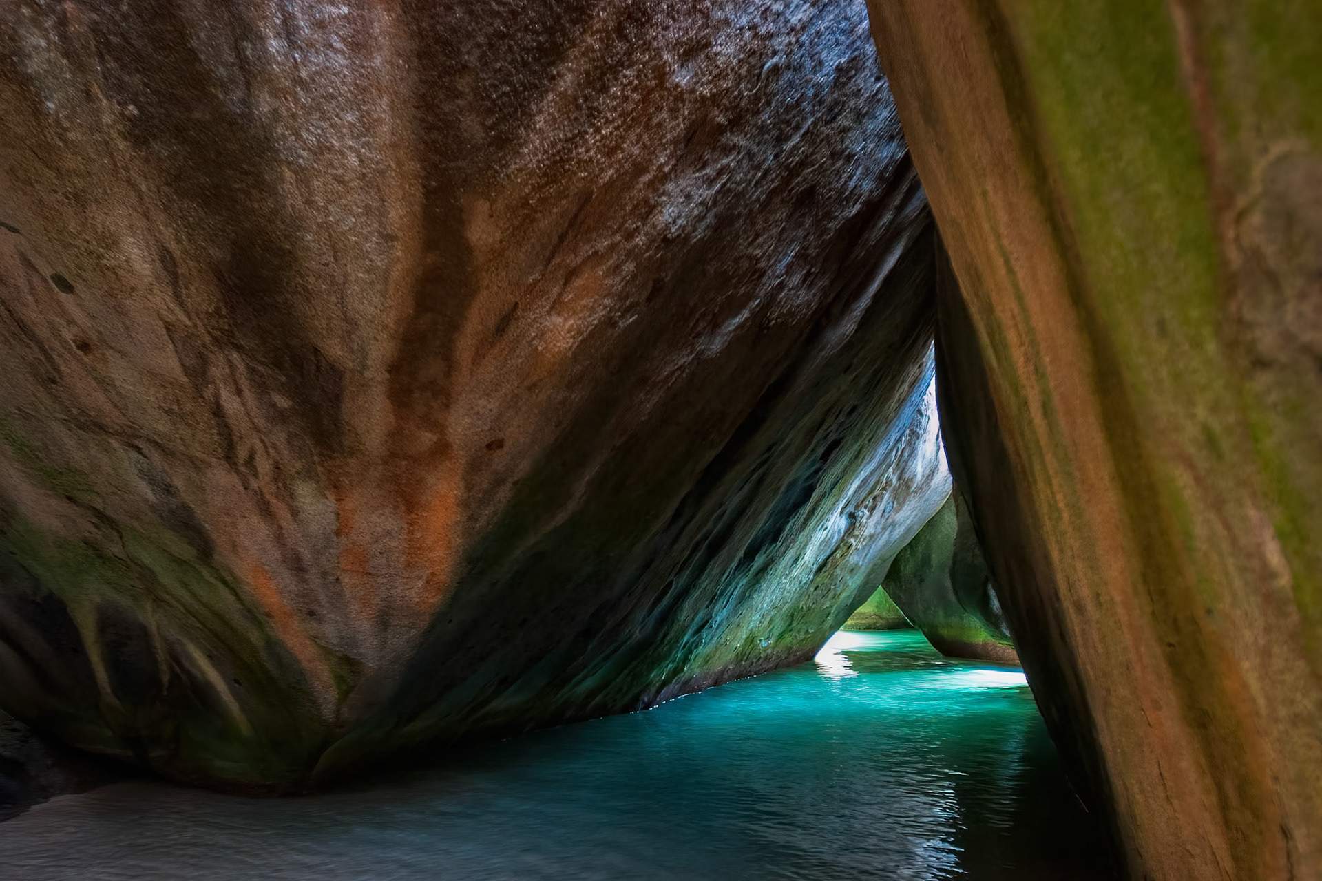 CHAMBER OF STONE AND LIGHT  |  Some places feel almost too extraordinary to be real. The Baths on Virgin Gorda is one of them. Towering granite boulders, sculpted by wind, waves, and time, create a labyrinth of hidden passages, quiet pools, and shafts of light that seem to belong in another world.I spent hours exploring these natural chambers, wading through crystal clear water beneath rocks the size of buildings. Around every corner was a new composition, where emerald reflections danced across stone polished by centuries of tides.What captivated me most was the sense of discovery. Standing in this narrow passage, surrounded by massive granite walls and luminous Caribbean water, I felt less like a traveler and more like an explorer stepping into a secret place few people have ever seen. It is one of those rare locations where nature effortlessly outdoes even the most ambitious architect.