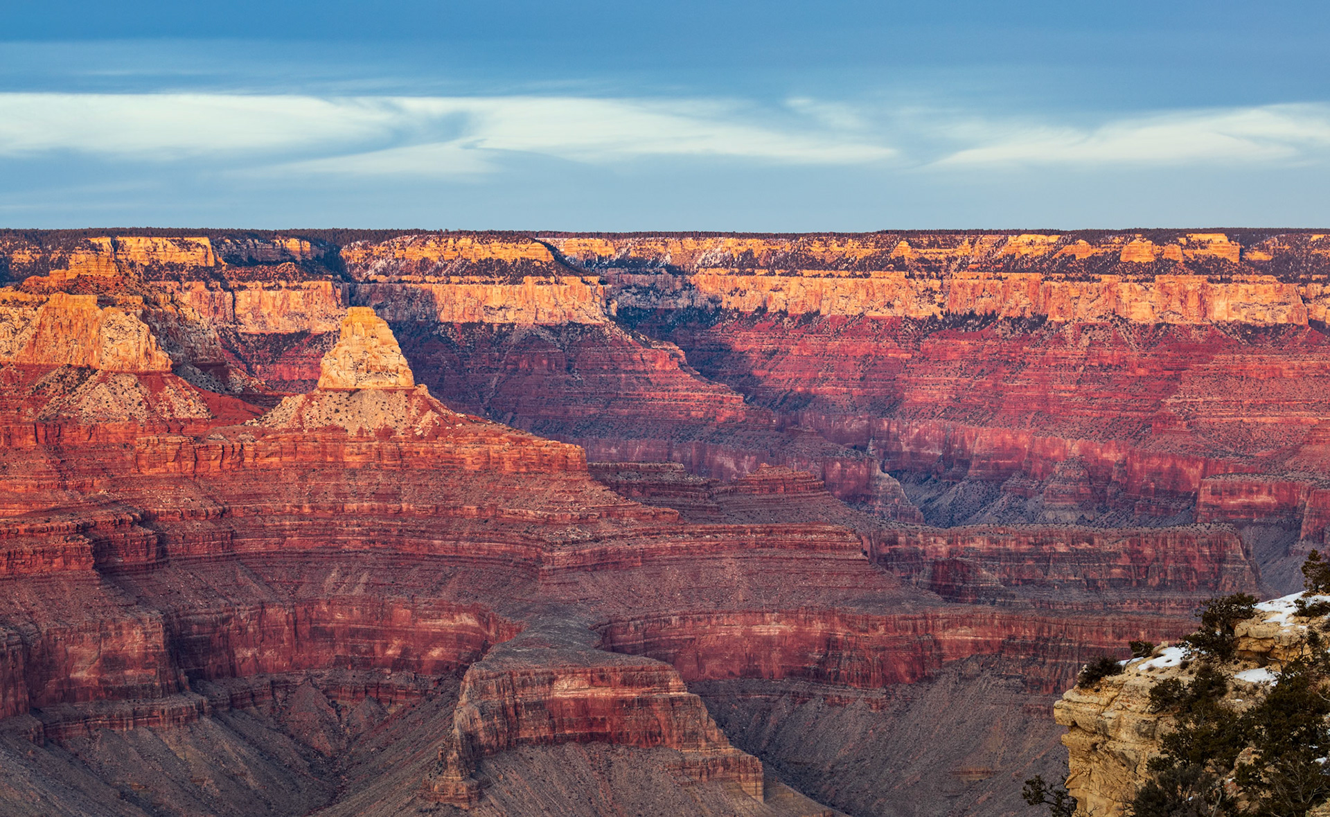 WHERE TIME RESTS  |  One of the surprises of the Grand Canyon is not what lies below, but what lies beyond.Standing at the rim, my eyes were naturally drawn into the maze of buttes, mesas, and deep chasms carved into the canyon's depths. Yet beyond all that complexity stretched a remarkably level horizon. The contrast was striking. Millions of years of erosion had sculpted one of the most intricate landscapes on Earth, while the plateau above remained almost perfectly flat.The scene felt like a lesson in perspective. The canyon often steals the attention, but the broad, quiet plateau tells an equally important part of the story. Before the Colorado River began its patient work, this entire region was once part of a vast elevated plain. What remains today is a glimpse into both the landscape that was and the masterpiece that followed.As the last light brushed the upper cliffs, layers of crimson, rose, and gold revealed the canyon's immense depth. The flat horizon beyond served as a reminder that nature's most dramatic creations often begin with something deceptively simple.