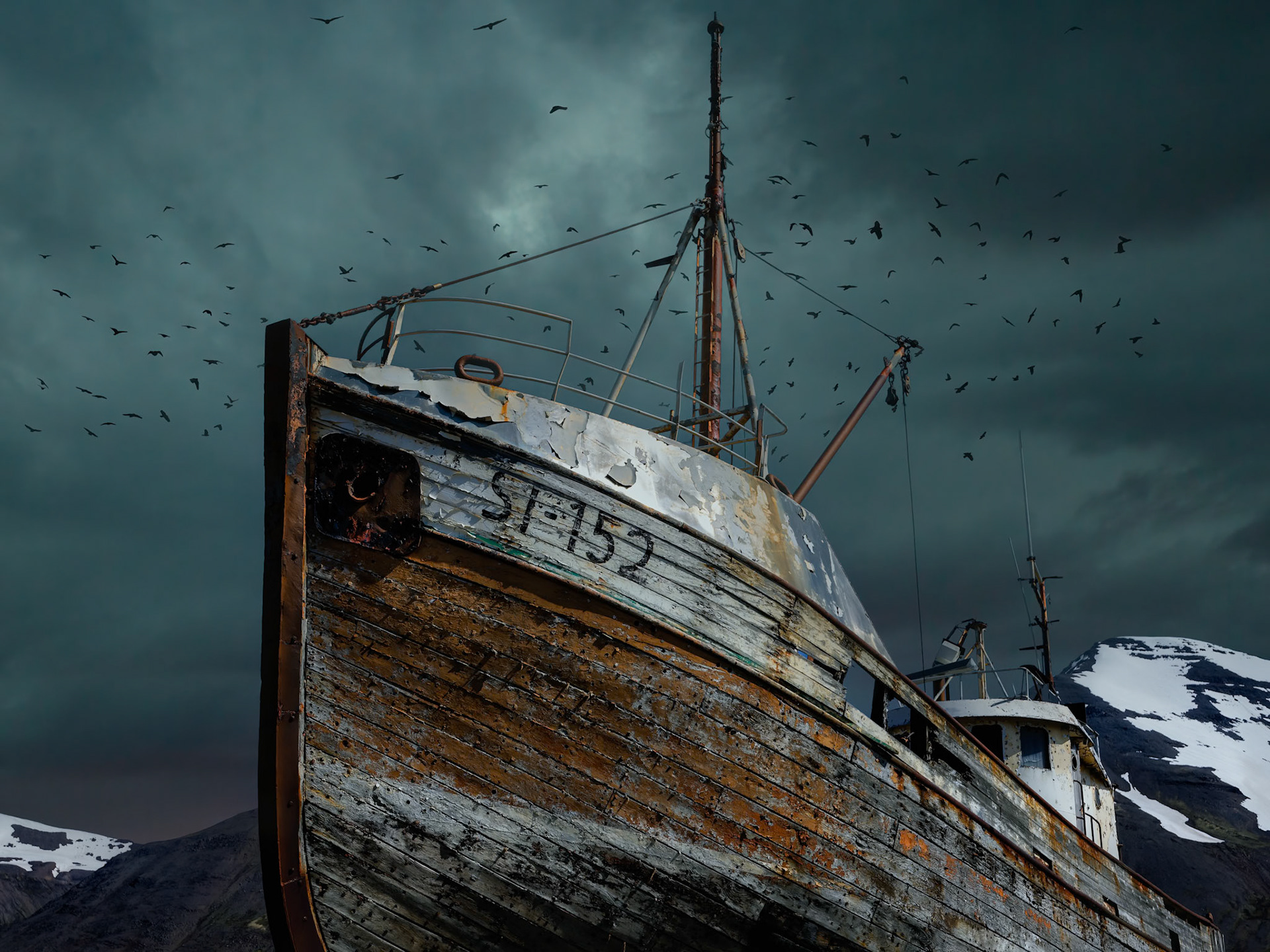 OUT OF ITS ELEMENT  |  Weathered by years at sea and now surrendered to the elements, this aging vessel stands beneath gathering clouds as if bracing for one final voyage. The peeling paint, rusted steel, and circling birds tell a story of endurance, while the darkening sky hints at nature's enduring power.