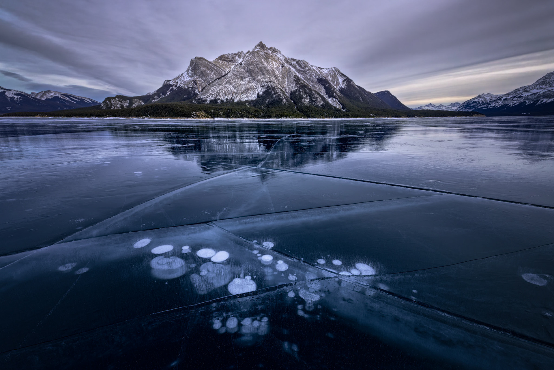 FROZEN BREATH  |  Each winter, Abraham Lake creates one of the most remarkable natural galleries in North America. Methane gas rises from the lakebed throughout the season, but instead of reaching the surface, it becomes trapped as the lake freezes layer by layer. The result is a visual record of time itself, preserved beneath the ice.