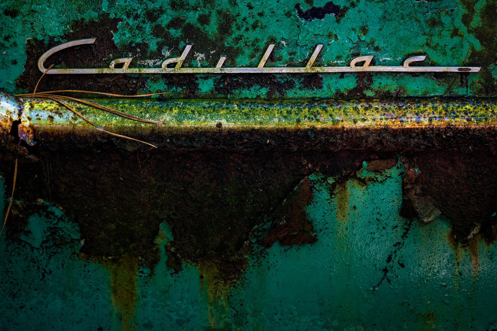 CADILLAC RELIC  |  There is something poetic about seeing a name associated with luxury and aspiration slowly surrendered to time.The elegant Cadillac script stretches across the frame like a signature from another era, still graceful despite the decades that have passed. Beneath it, layers of corrosion, peeling paint, and oxidized metal reveal a history written not in words, but in texture. What was once a flawless surface has become a landscape of rust, color, and decay.
