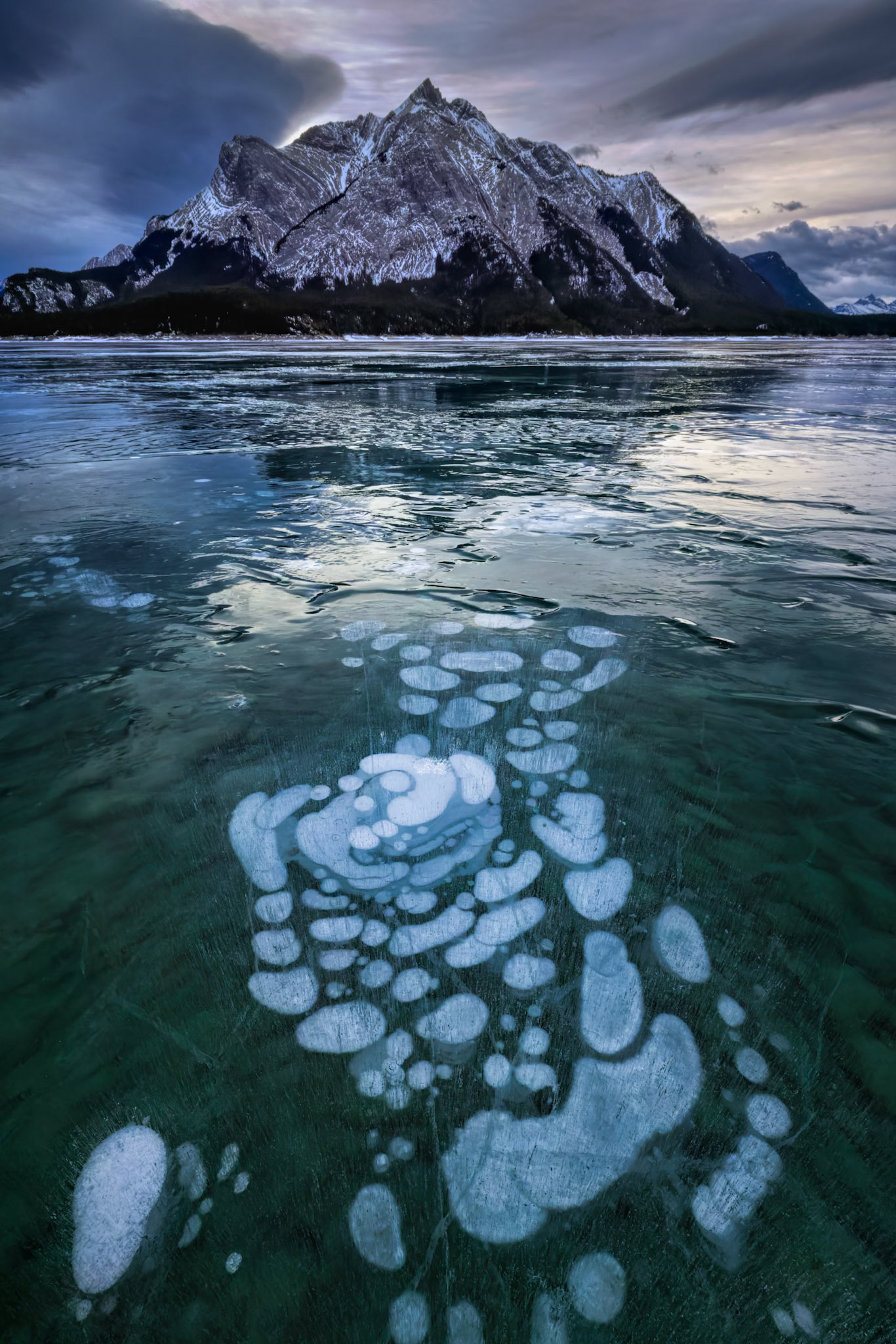 FROZEN FOOTSTEPS |  LAYERS OF ICE BUBBLES LIKE FOOTSTEPS LEAD TOWARD THE MOUNTAIN.