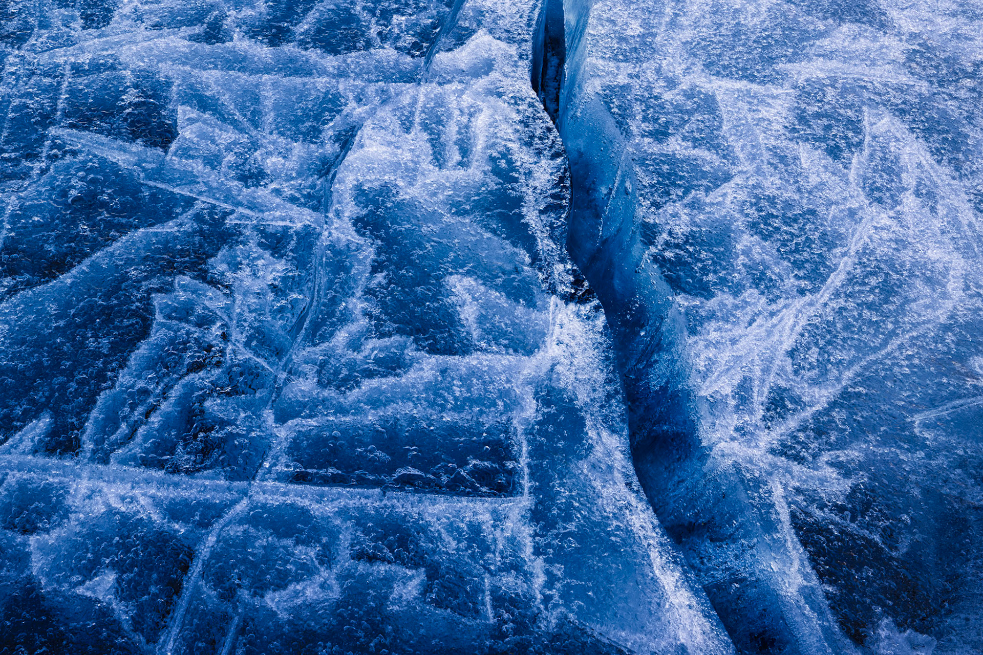 FRACTURED  |  At first glance, ice appears solid, permanent, and unchanging. Yet beneath the surface, it is constantly responding to forces both seen and unseen. Temperature swings, wind, water movement, and pressure all leave their mark, creating intricate patterns that reveal a landscape in transition.