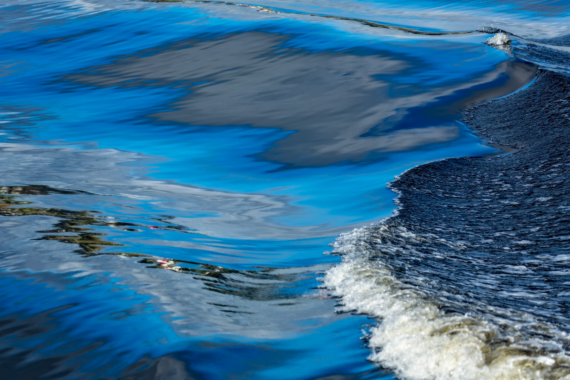 GLASS TIDE  |  The surface of the water becomes a liquid mirror, transforming sky, clouds, and shoreline into flowing ribbons of color and light. For a fleeting moment, the boundary between water and reflection disappears, leaving behind an abstract seascape sculpted by the rhythm of the tide.