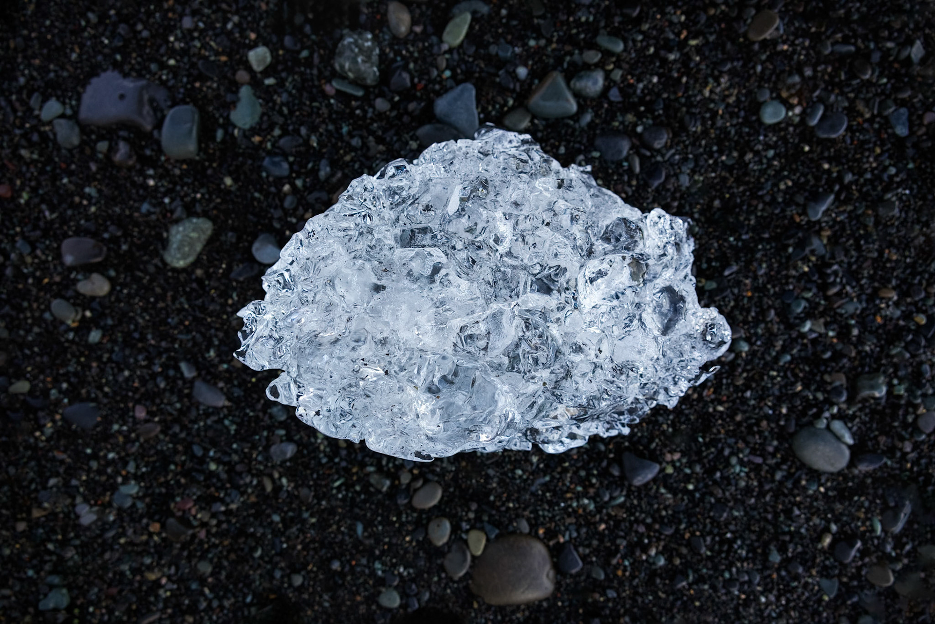 ARCTIC DIAMOND  |  Along Iceland's Diamond Beach, fragments of glacier ice are scattered across black volcanic sand like gemstones from another world. Polished by the relentless motion of the North Atlantic, each piece catches the light differently, revealing a dazzling clarity that makes it easy to understand how the beach earned its name.What drew me to this small fragment was its resemblance to a cut diamond. The intricate facets, crystal clear transparency, and sparkling highlights transformed a piece of ancient glacier ice into something that looked more like a precious jewel than frozen water. Against the dark sand, every detail stood out with remarkable contrast.The irony is that these "diamonds" are among the most fleeting treasures on Earth. Ice that may have spent centuries locked within a glacier can disappear in a matter of days once it reaches the shore. For a brief moment, however, nature creates a masterpiece that rivals anything found in a jeweler's display case.