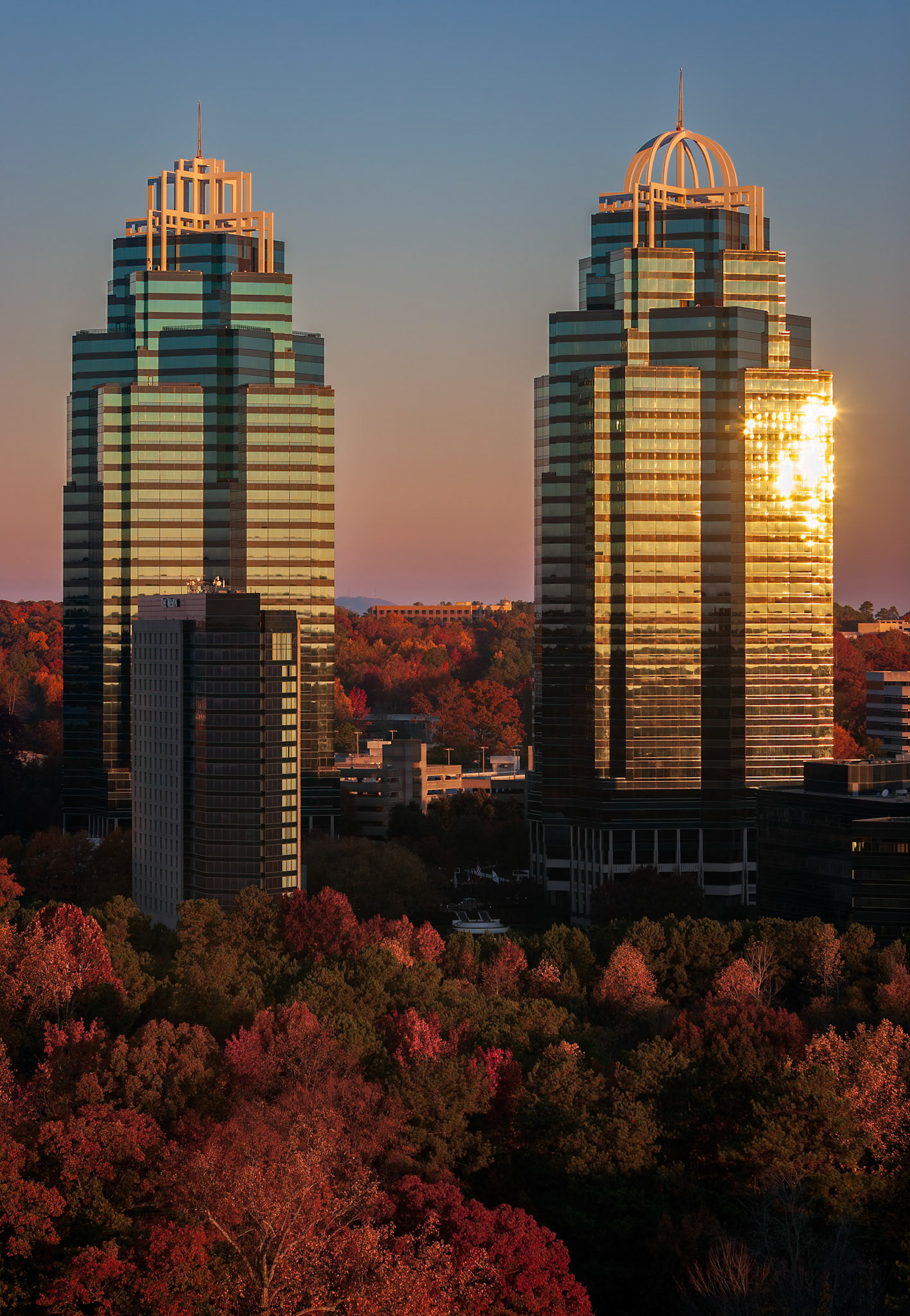AUTUMN FINDS THE CITY  |  The setting sun found the Queen tower at exactly the right moment, turning its glass facade into a brilliant beacon above Atlanta's autumn canopy. The display lasted only a few minutes before the light shifted and the glow disappeared.I've photographed these iconic towers many times over the years, but autumn always adds something special. The contrast between the modern skyline and the rich colors below is a reminder of why Atlanta is often described as a city in a forest.What stays with me from this evening is how fleeting the moment was. The towers remain year round, but the combination of peak fall color and perfect light is something that can never be scheduled, only appreciated when it appears.