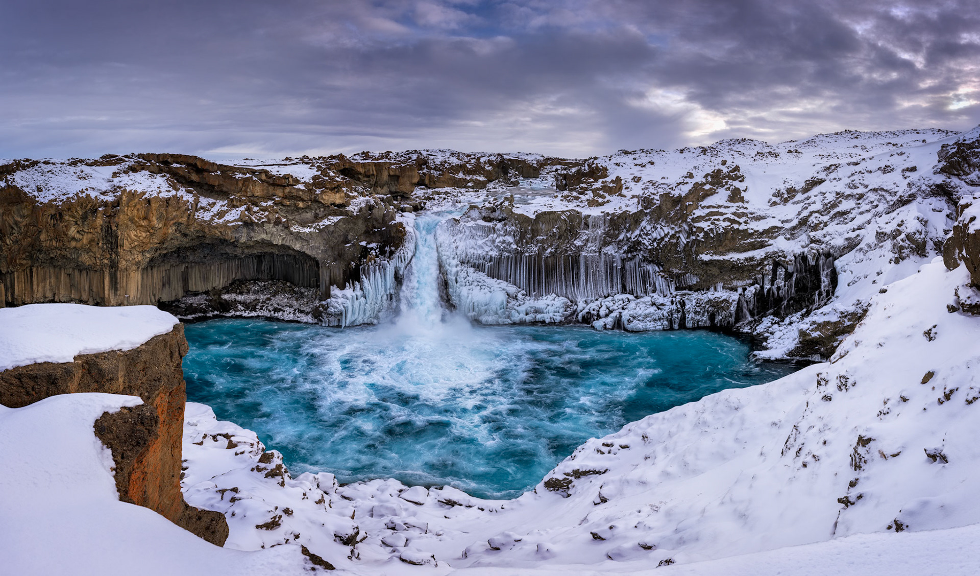 THE BLUE CAULDRON  |  Winter transforms Iceland's Aldeyjarfoss into a landscape that feels almost otherworldly. Snow blankets the volcanic terrain while turquoise glacial water crashes into a frozen basin, surrounded by towering basalt columns draped in ice. The contrast between fire formed rock and winter's delicate touch creates a scene of extraordinary beauty.What makes this image especially meaningful is that it is not a single photograph, but a panorama composed of 95 individual images. Every section of the canyon, waterfall, and surrounding landscape was carefully captured and stitched together to preserve the immense scale and intricate detail of this remarkable place.Standing there, I was struck by nature's ability to balance power and elegance. The waterfall thundered into the pool below while icicles clung to the basalt cliffs like crystal organ pipes. The result is a scene that rewards exploration, where every corner reveals another texture, pattern, or detail hidden within Iceland's winter.
