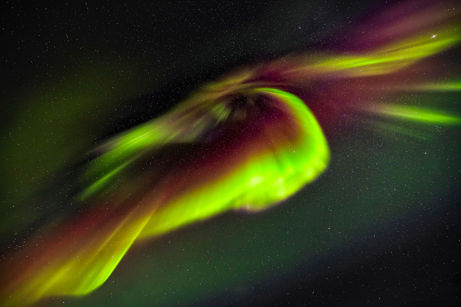 THE PULSE OF THE NORTH  |  Most aurora displays dance across the horizon. A coronal aurora is different. When the northern lights pass directly overhead, the curtains of light appear to converge toward a single point, creating one of the rarest and most spectacular sights in the night sky.On this unforgettable night, vivid green ribbons intertwined with deep crimson and magenta hues, forming a celestial vortex above. Lasting only moments before shifting shape again, the display felt less like a natural phenomenon and more like a glimpse into another world. For many aurora photographers, witnessing a true coronal aurora is a once in a lifetime experience.