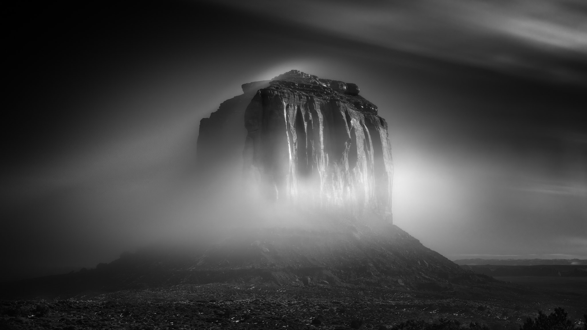 ALONE IN THE VEIL |  Monument Valley is photographed thousands of times each year, usually beneath brilliant blue skies or fiery desert sunsets. But on this winter morning, the landscape revealed a very different personality.A dense layer of fog drifted across the valley floor, wrapping itself around the sandstone buttes like a veil. Most photographers packed away their cameras, unable to see the formations clearly through the mist.I chose to wait.Using an eight minute exposure, I allowed time itself to become part of the image. The moving fog transformed from a collection of drifting clouds into a luminous, ethereal shroud. What had been a familiar landmark became something mysterious, almost supernatural.As the exposure progressed, the sandstone monolith emerged from the mist like an ancient apparition. The long exposure softened the movement of the fog while preserving the strength and permanence of the butte itself. For a brief moment, the landscape seemed suspended between reality and dream.What fascinates me most about this image is the contrast it represents. The fog is temporary, changing by the second. The rock has stood here for millions of years. One is fleeting. The other endures.The photograph became a study of both.A portrait of permanence wrapped in a veil of time.