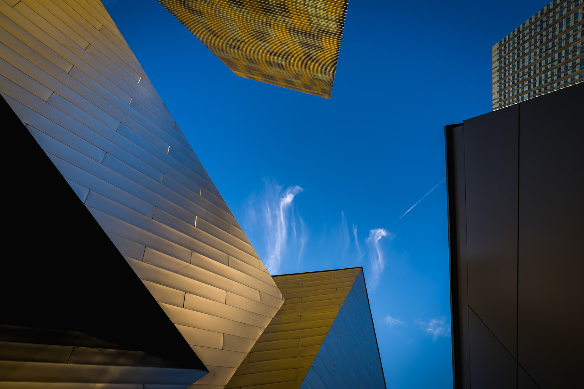 SKY GEOMETRY  |  Some of the most interesting photographs are hiding in places we walk past every day.Standing among the towering buildings of Las Vegas, I found myself surrounded by steel, glass, and concrete. Like most people, it would have been easy to focus on what was at eye level. Instead, I tilted my head skyward.Suddenly, the city transformed.Sharp architectural lines converged from every direction, creating an unexpected geometric composition against a deep blue desert sky. The buildings seemed less like structures and more like abstract shapes suspended in space. Wisps of cloud drifted through the opening overhead, softening the hard edges and adding a sense of motion to an otherwise rigid scene.What struck me most was how easily this view could be missed. Hundreds of people likely walked through the same spot that day without ever noticing the elegant symmetry above them. Photography often rewards curiosity, reminding us that a simple change in perspective can reveal an entirely different world.Sometimes the most beautiful view isn't in front of us.