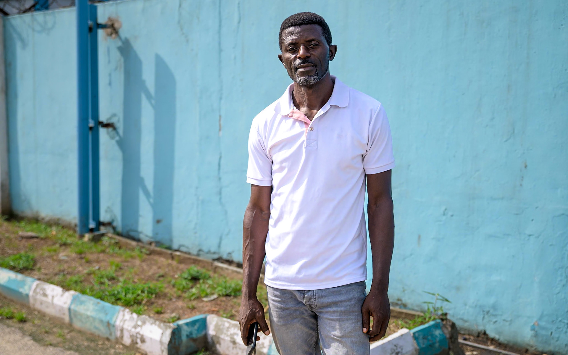 Evaristus, a refugee in Nigeria since 2019, poses in front of UNHCR office in Lagos, during a monitoring mission. After a successful carpentry training, he started an apprenticeship in a furniture workshop, carving wood and upholstering chairs. He also works on his own on the side. He would like to see more people taking up these trainings, and "give hope to people who lost hope".PoC: Refugee
