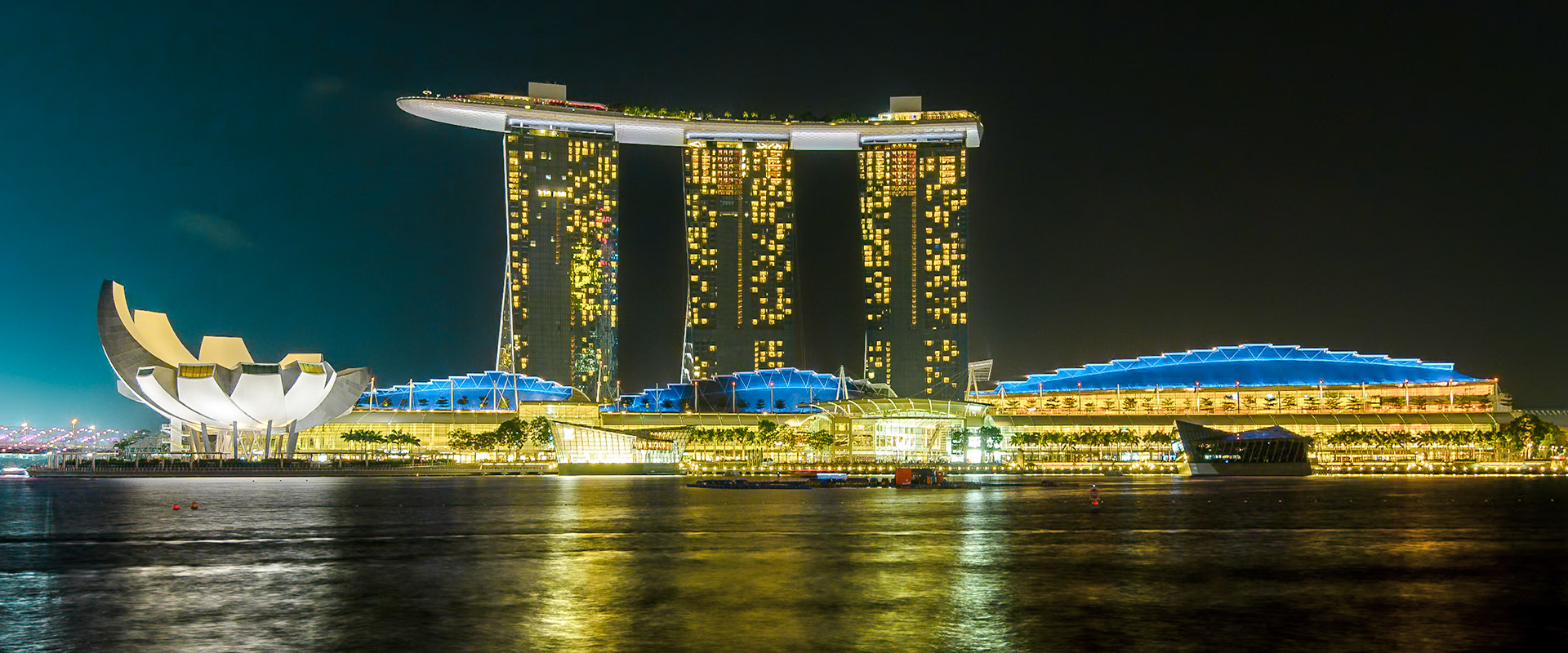 Singapore - 17 Jul 2014: the ArtScience Museum and the Sands resort and casino reflect in the Marina Bay at night, in Singapore