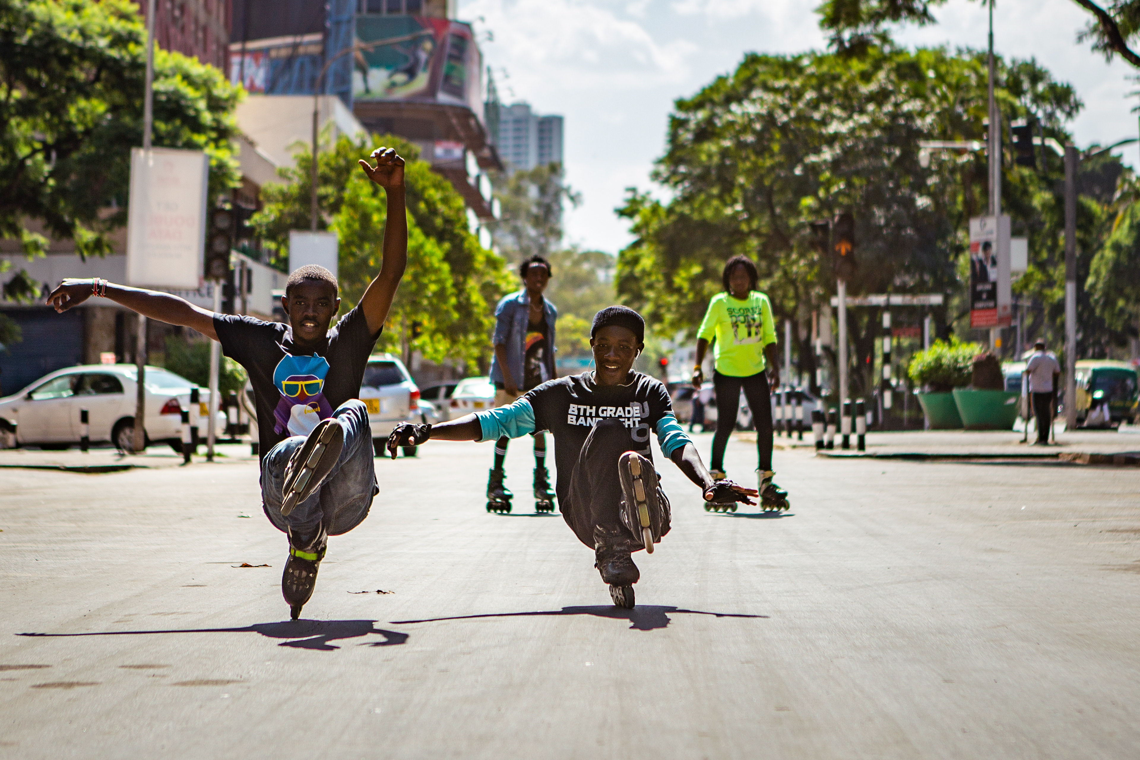 Michael Munge and Jesse Otumba practice a move between cars on a street in central Nairobi.