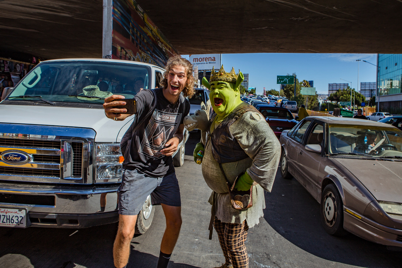 Having a unique look is a common strategy to stand out from the numerous other people working the line. This man, who identified himself only as Shrek, alternates between taking pictures for tips and washing car windshields.