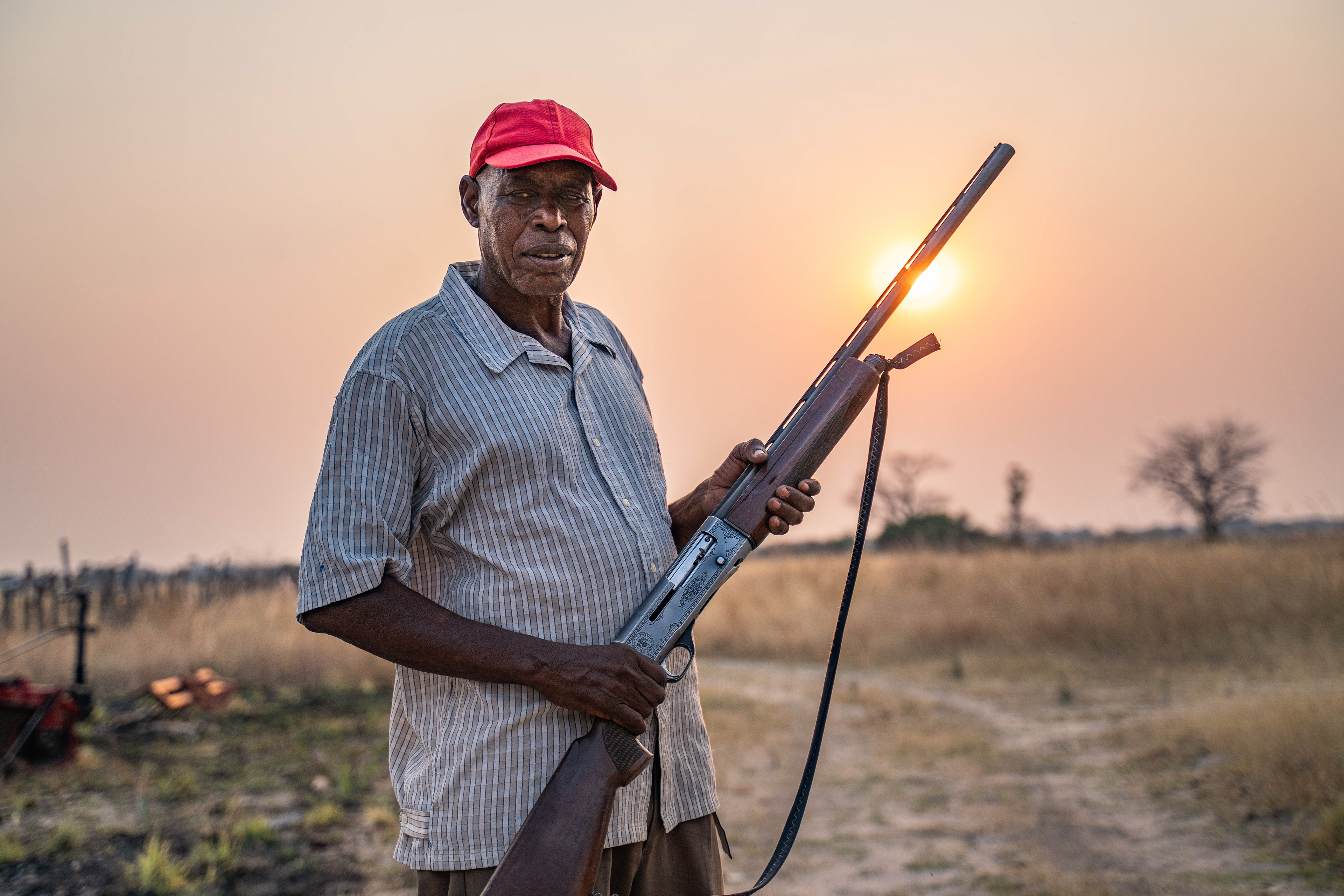 Farmer Grandson Kenalemang gets ready for another night guarding his farm from elephants, who just last week broke through a fence and ate the rest of his crops. Living on the edge of Chobe National Park, he uses a shotgun (legally) to try and scare animals away.