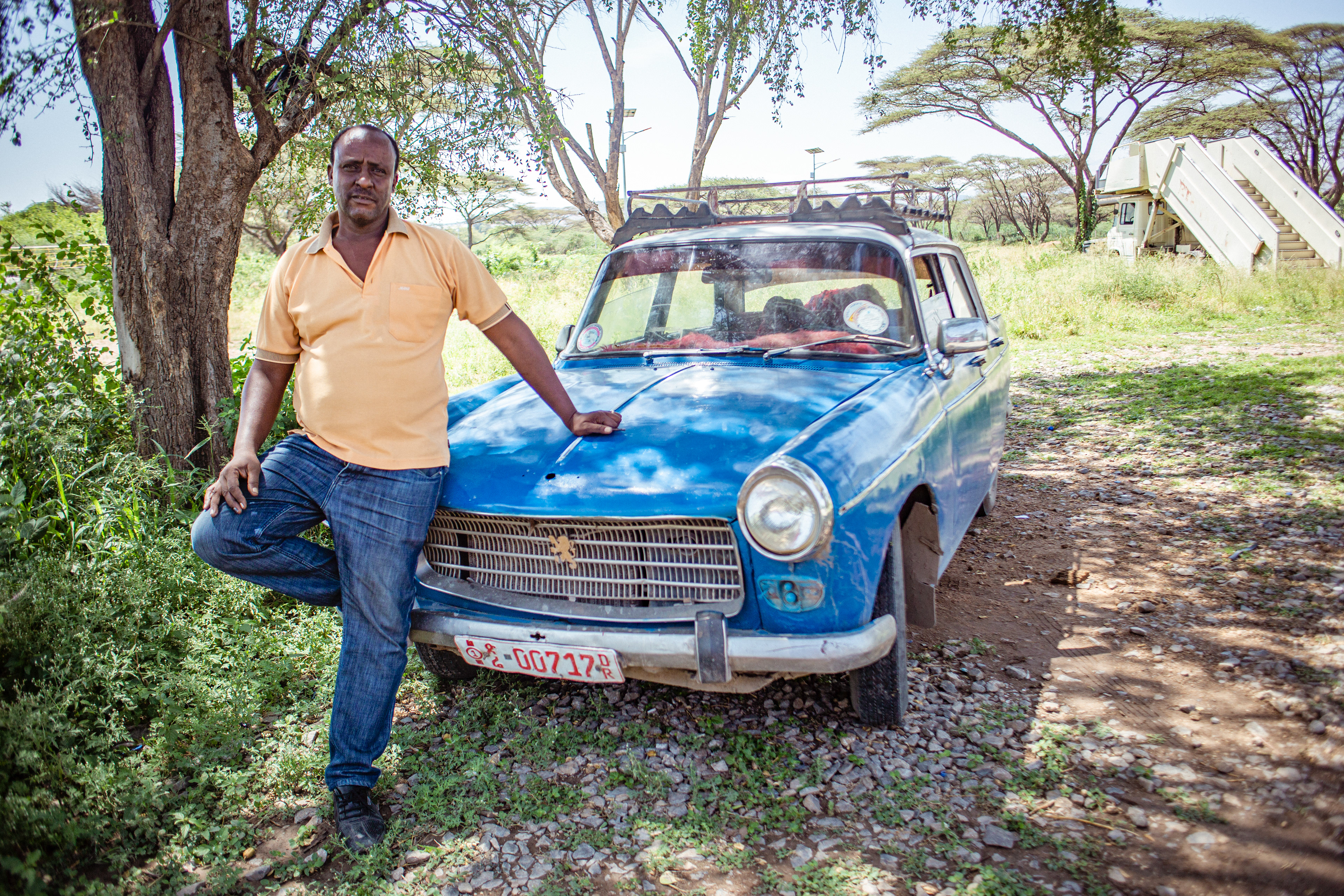 Belete Mulatu stands in front of his taxi, which he believes won’t be on the road much longer. “They won’t be on the road more than two or three years,” he says. “The new Prime Minister will change things.”