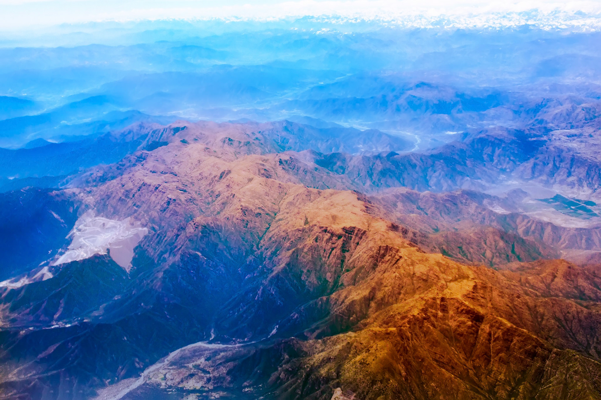 View from the airplane to the high mountain range