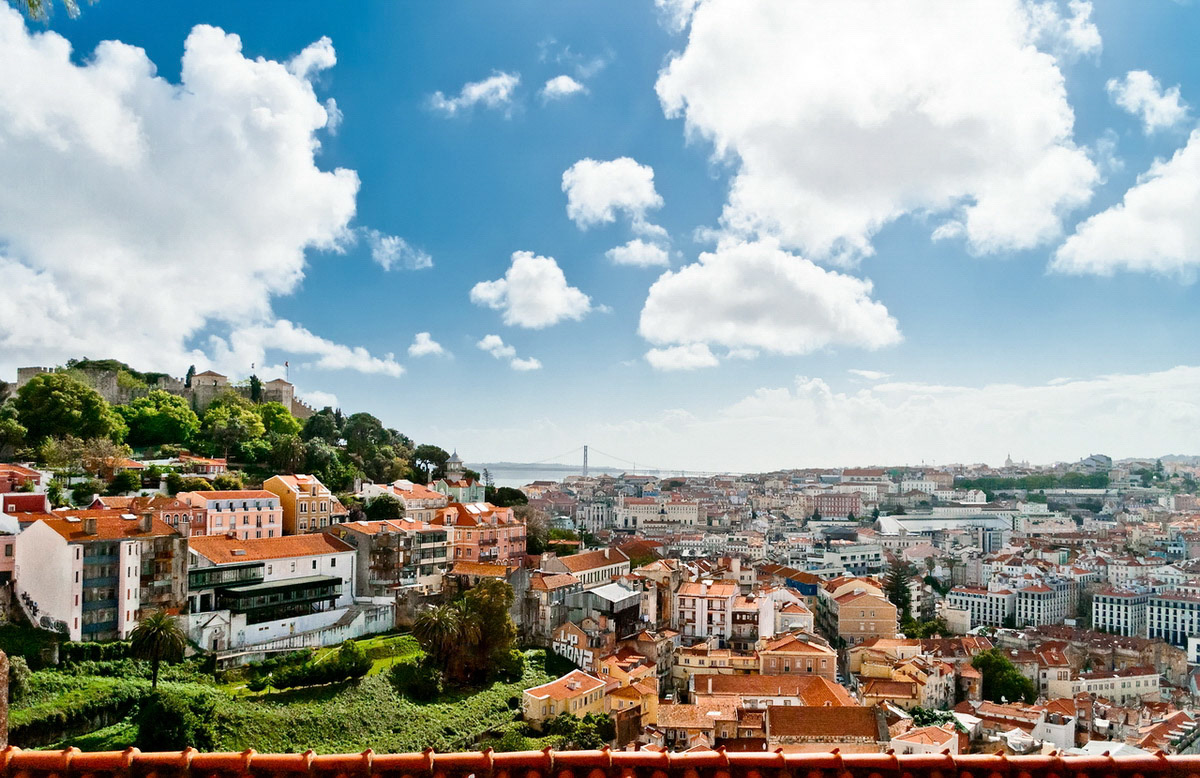 Lisbon view over red roofs of district of Baixa, St. George's Castle, Tagus River and Bridge of 25th April.