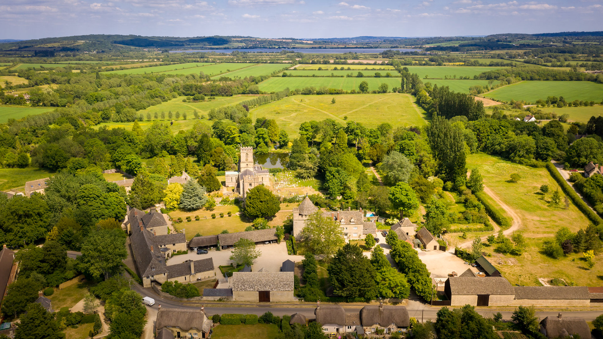 Stanton Harcourt, St Michaels church, the Manor Farmhouse and Farmoor reservoir in the distance