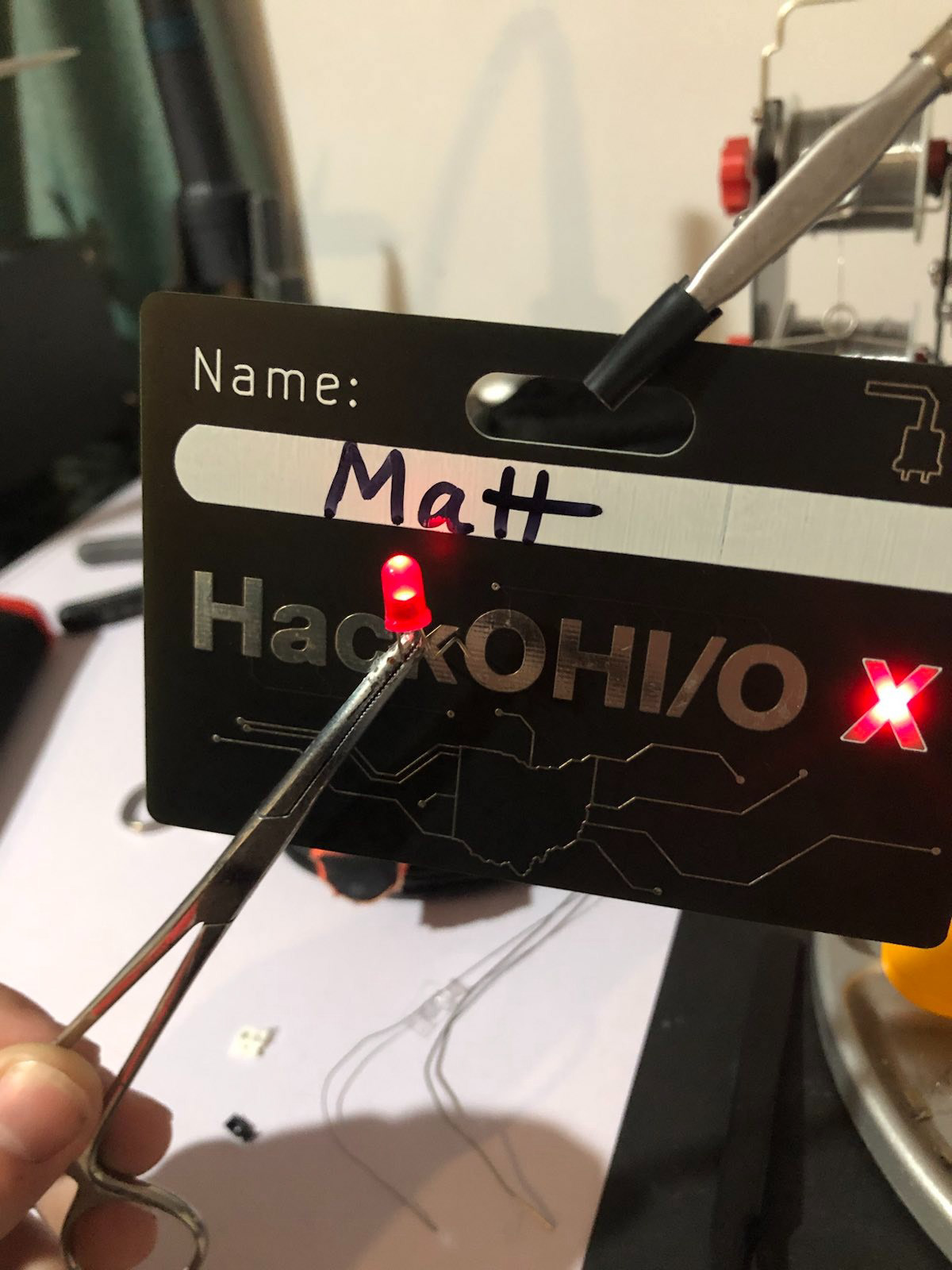 A "hidden" feature. An LED can be pressed against the word "Hack" and "OHI/O" to test it.