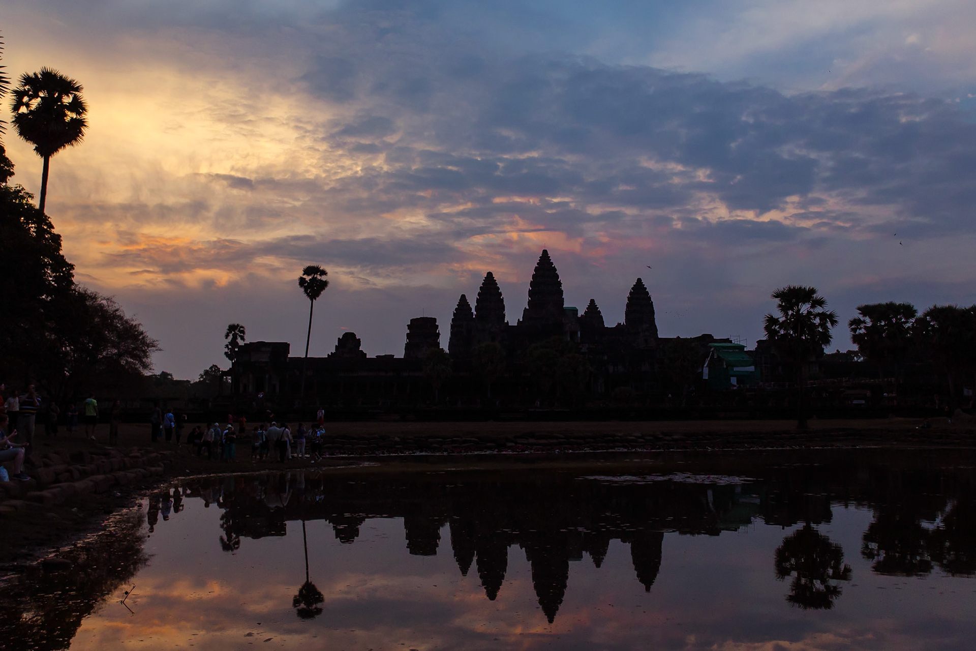 Angkor Wat is a temple complex at Angkor, Cambodia, built by King Suryavarman II in the early 12th century as his state temple and capital city. As the best-preserved temple at the site, it is the only one to have remained a significant religious centre since its foundation – first Hindu, dedicated to the god Vishnu, then Buddhist. The temple is at the top of the high classical style of Khmer architecture. It has become a symbol of Cambodia, appearing on its national flag, and it is the country's prime attraction for visitors. The modern name, Angkor Wat, means "City Temple".