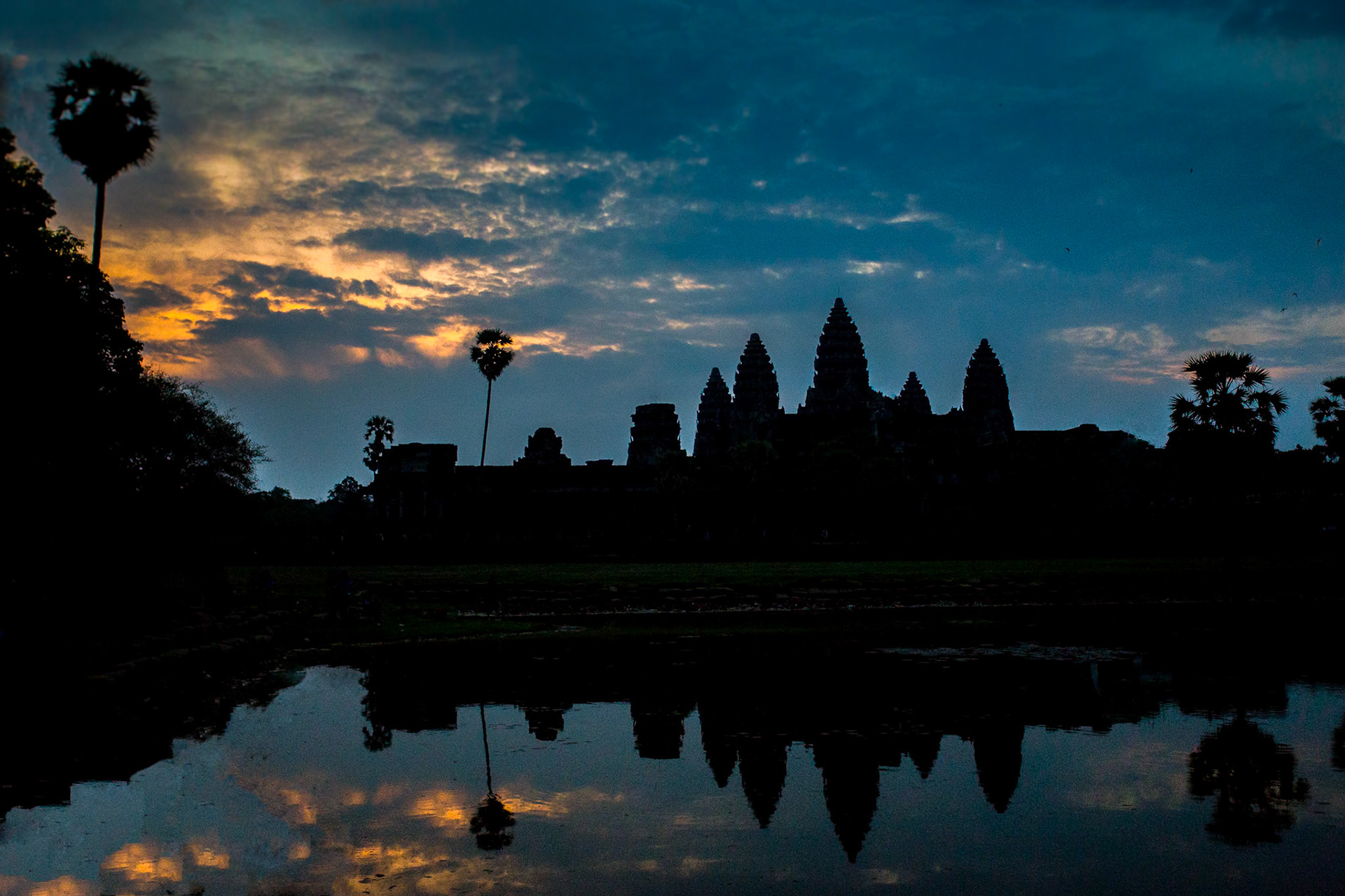 Angkor Wat is a temple complex at Angkor, Cambodia, built by King Suryavarman II in the early 12th century as his state temple and capital city. As the best-preserved temple at the site, it is the only one to have remained a significant religious centre since its foundation – first Hindu, dedicated to the god Vishnu, then Buddhist. The temple is at the top of the high classical style of Khmer architecture. It has become a symbol of Cambodia, appearing on its national flag, and it is the country's prime attraction for visitors. The modern name, Angkor Wat, means "City Temple".