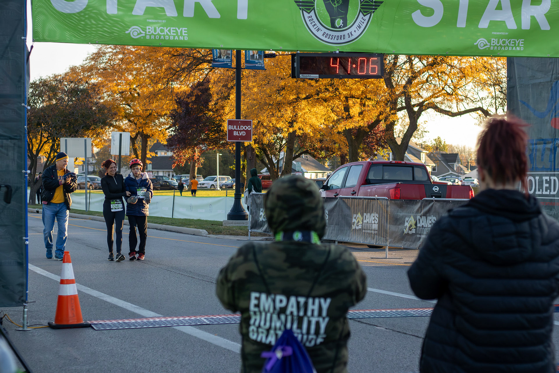 Angel Burns and Megan Claybough watching as Heather Radosti and Zander Puttman cross the finish line.