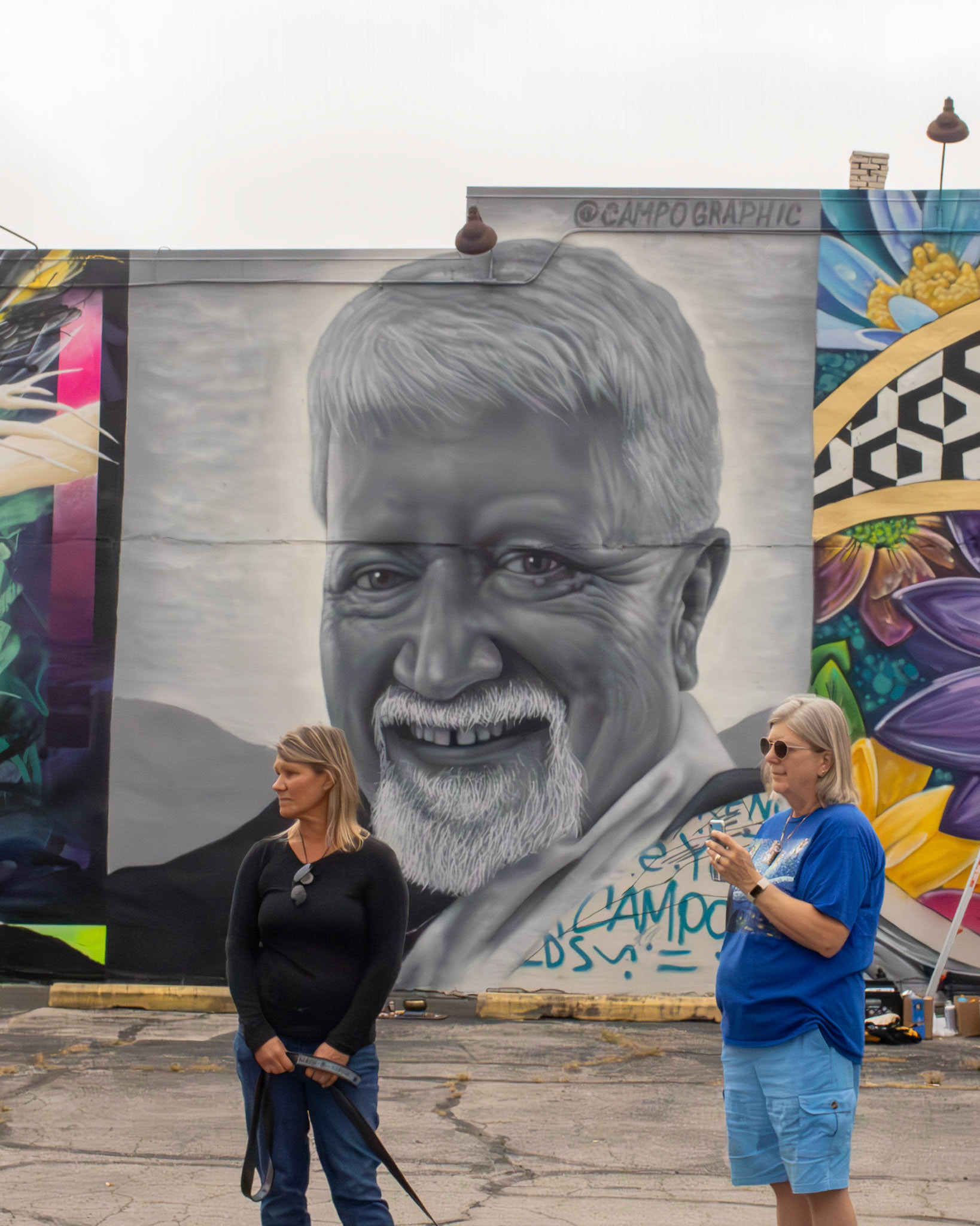 Family of the muralist Campo Graphic standing in front of a mural of the late Gary Fields, father of Campo.