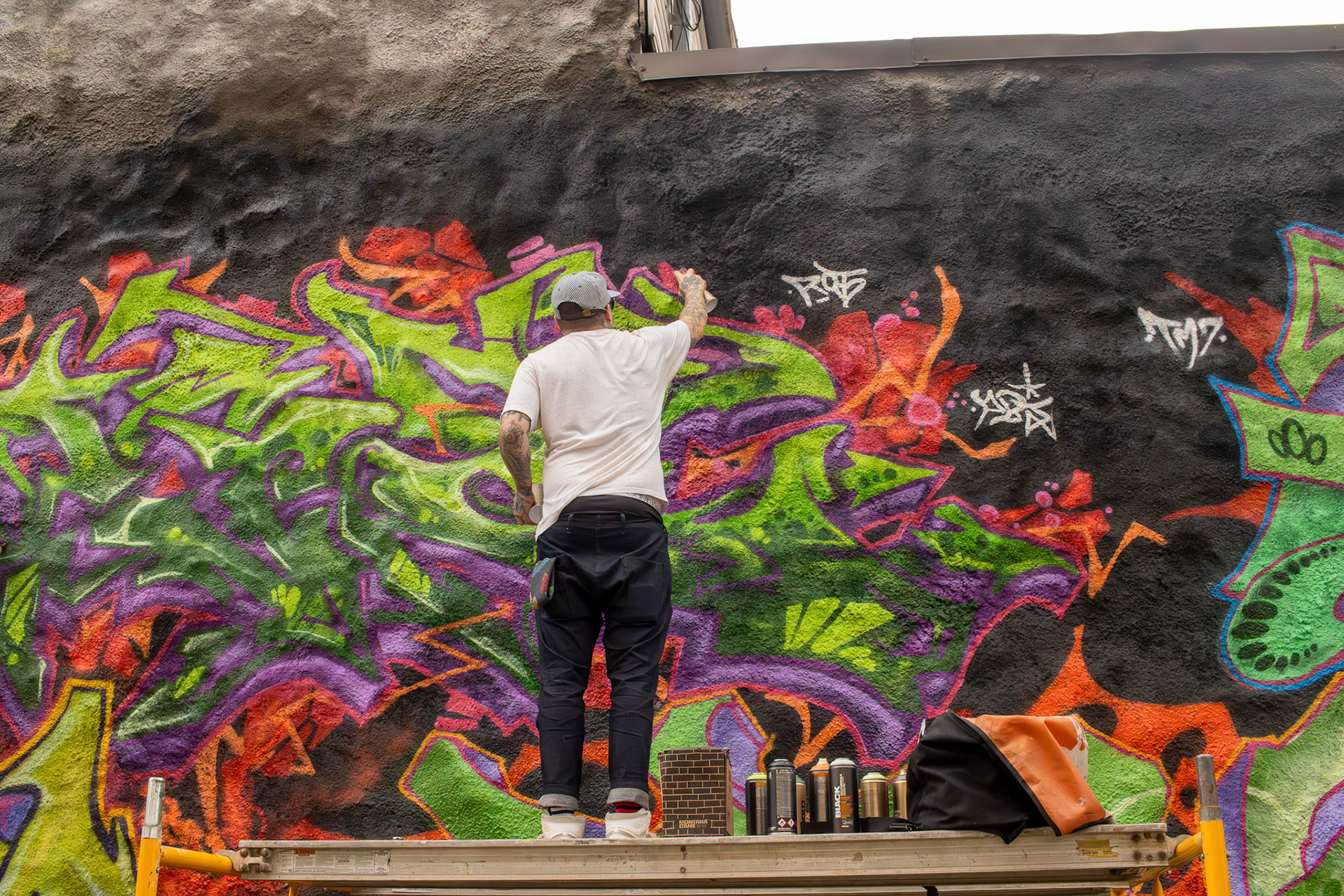 Columbus graffiti artist "Image" putting the finishing touches on a collaborative mural that spanned across several feet.