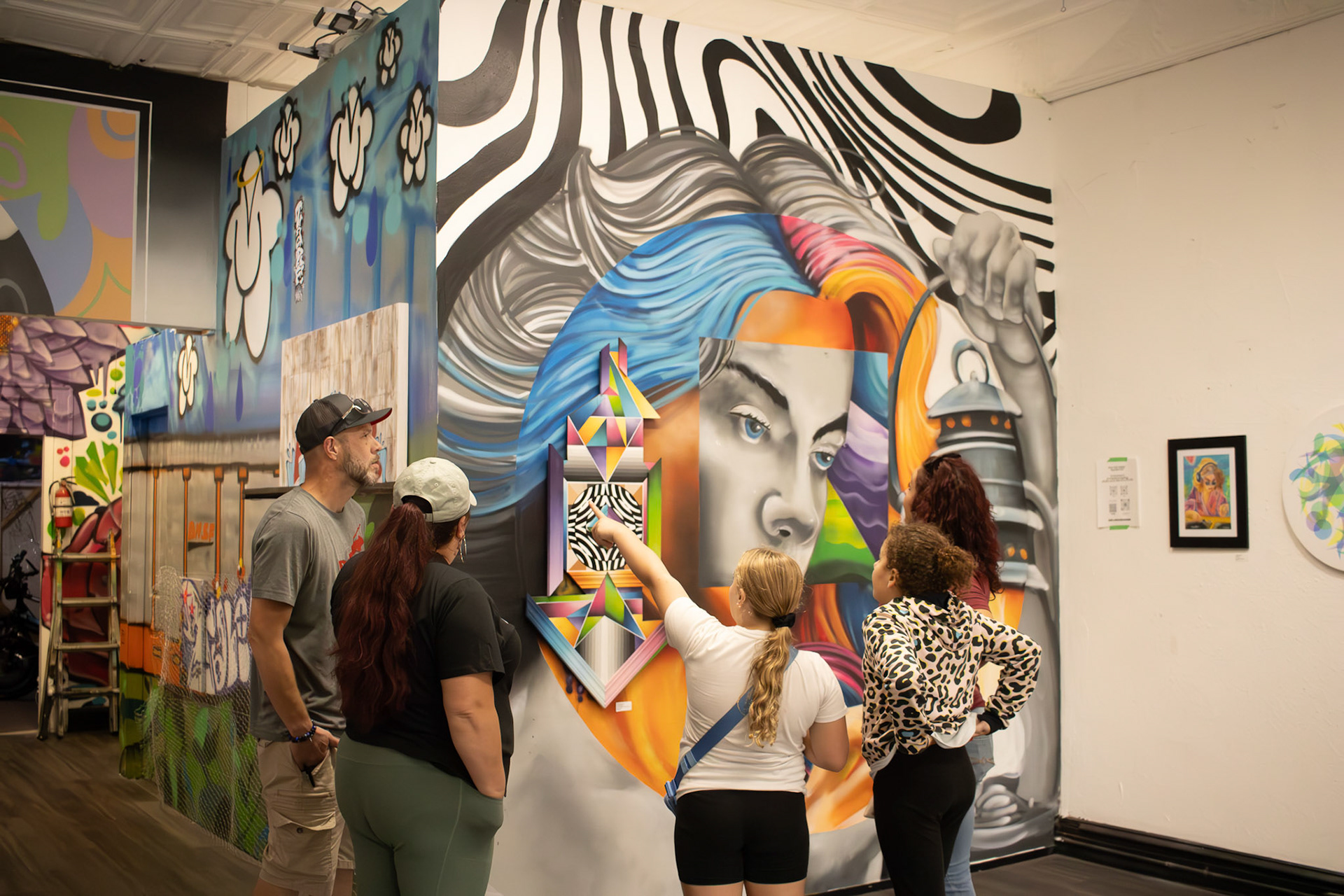 Local spectators inspect the artwork displayed in the River East Gallery