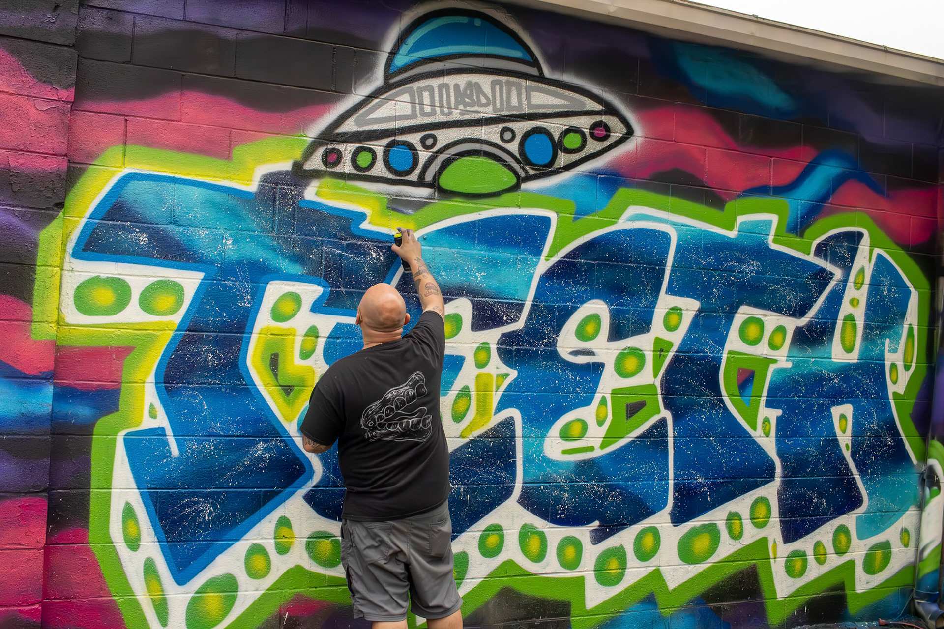 Grafitti artist "Teeth" creates a signature mural facing a nearby East Toledo neighborhood.