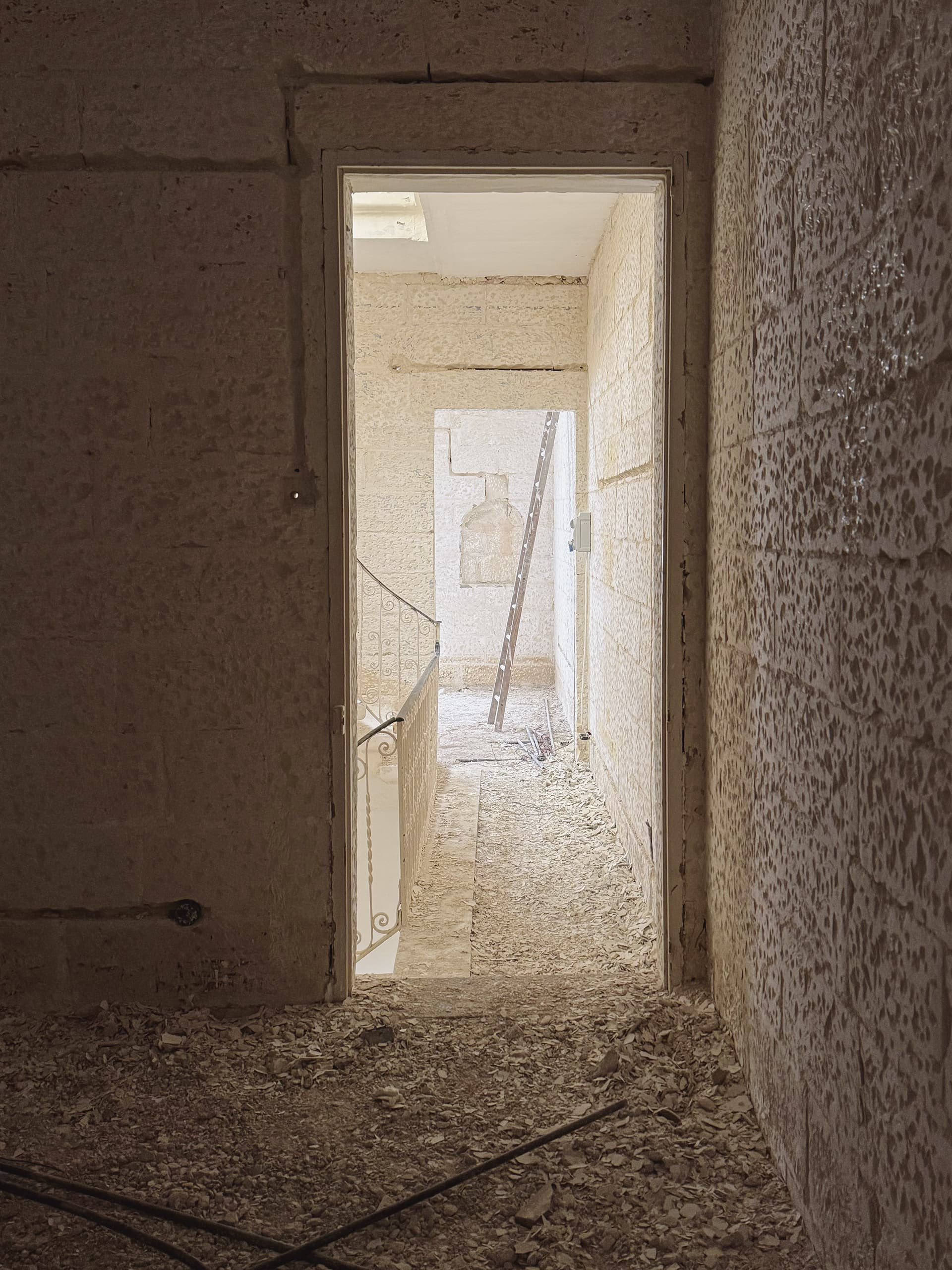 Hacking of all interior limestone masonry walls.