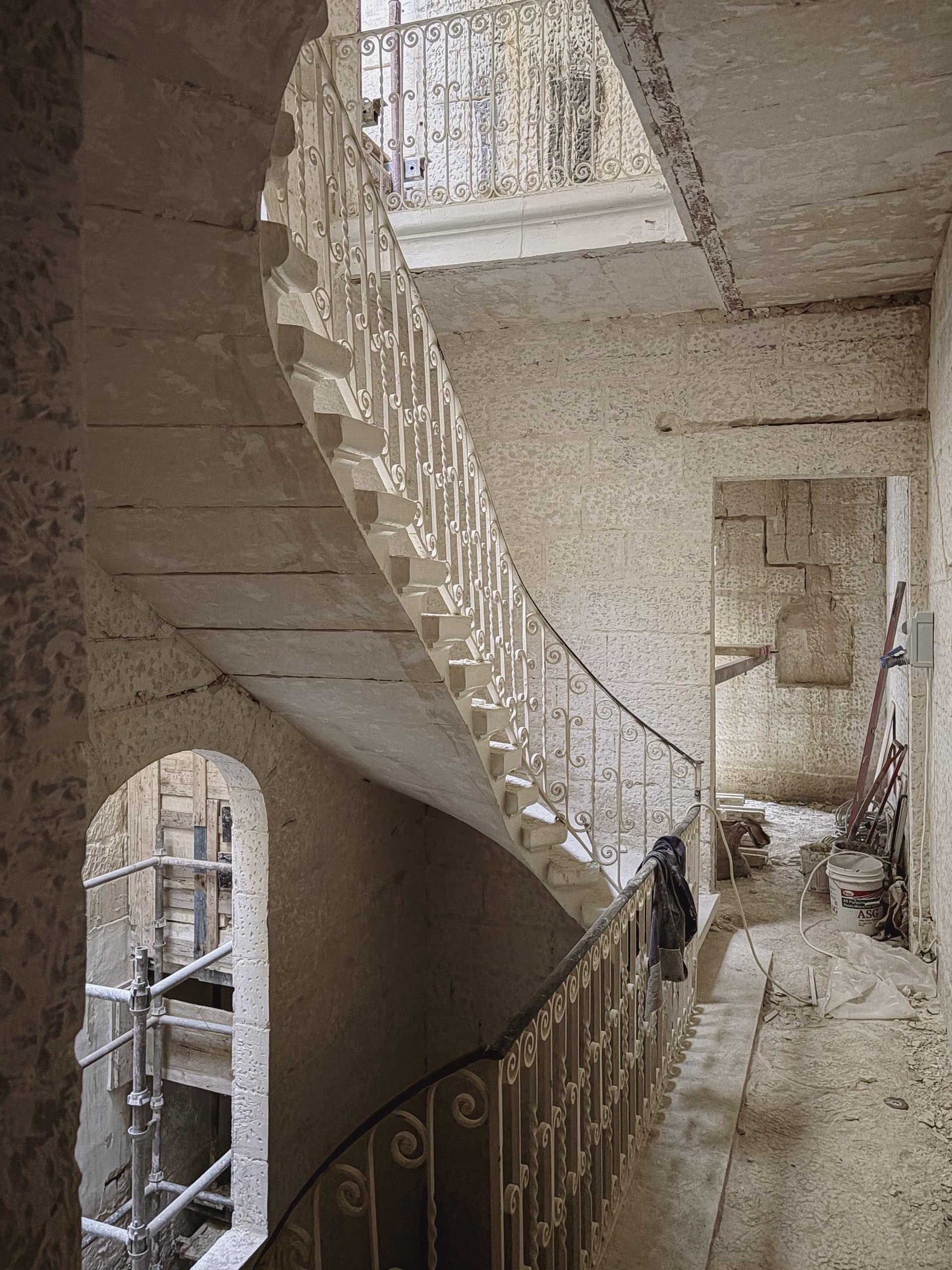 Limestone staircase with wrought iron railing.