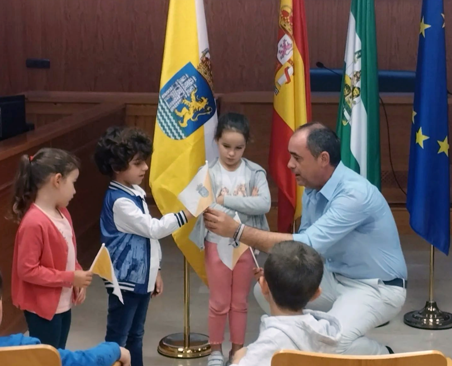 El alcalde de Castilblanco de los Arroyos, José Manuel Carballar Alfonso, entrega a escolares del municipio la flamante bandera de la localidad.